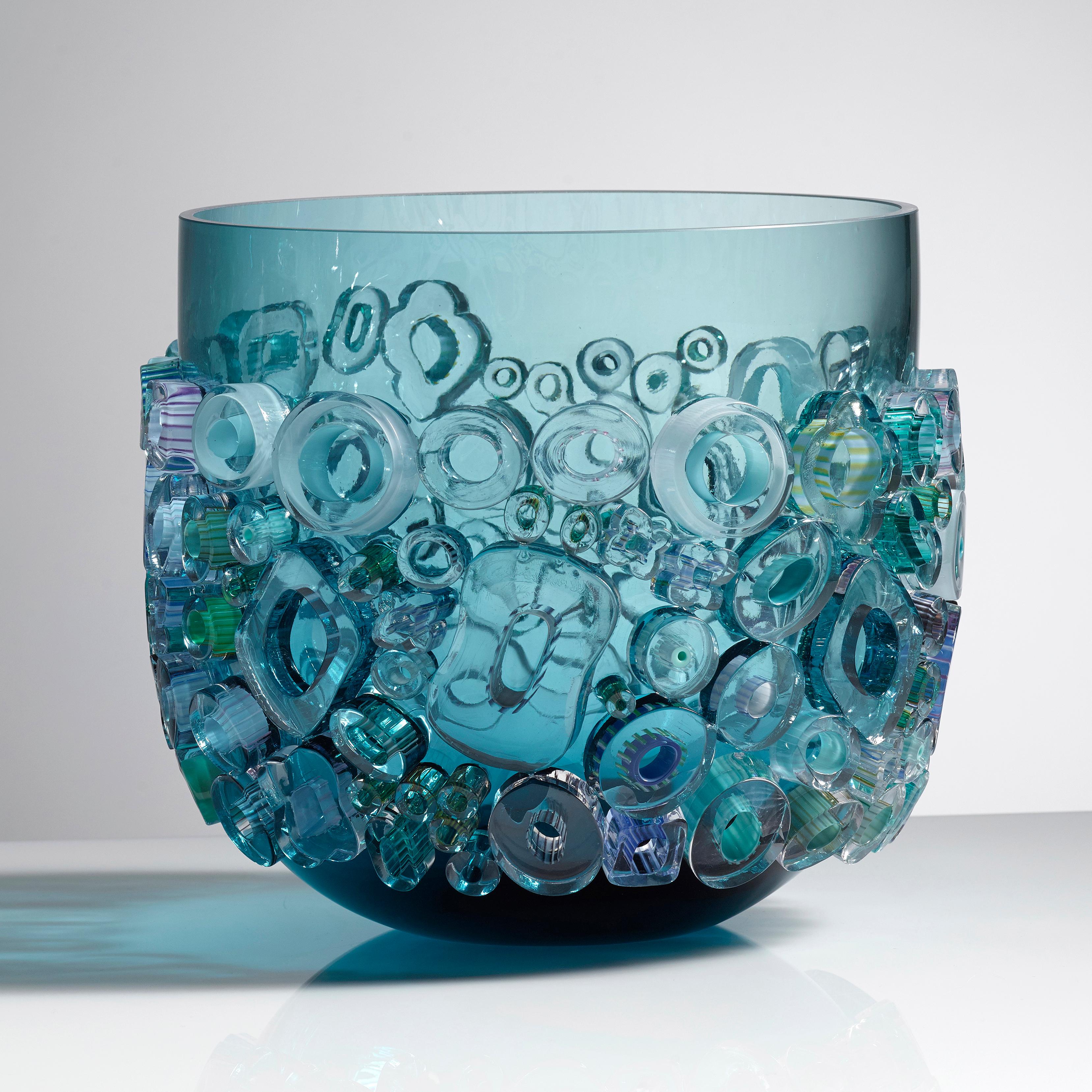 Common Ray in Aqua Light is a unique handblown and crafted vase & artwork / bowl / centrepiece by the German artist, Sabine Lintzen. The initial inner form is free-blown and adorned with various individually shaped murrini, all created in a mix of