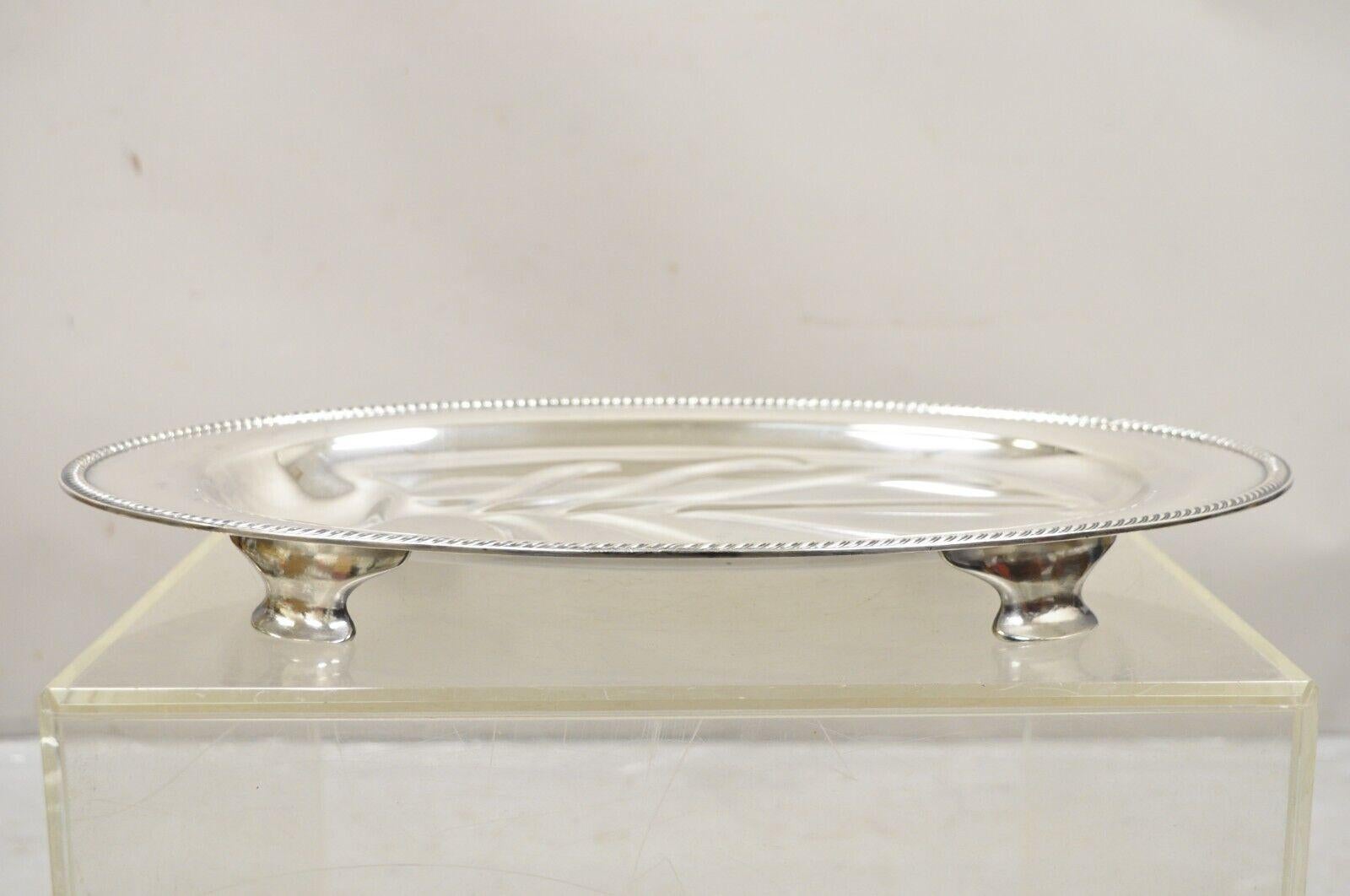 Vintage Community Plate English Regency Style Silver Plated Oval Meat Cutlery Serving Platter. Circa Mitte des 20. Jahrhunderts.
Abmessungen: 2