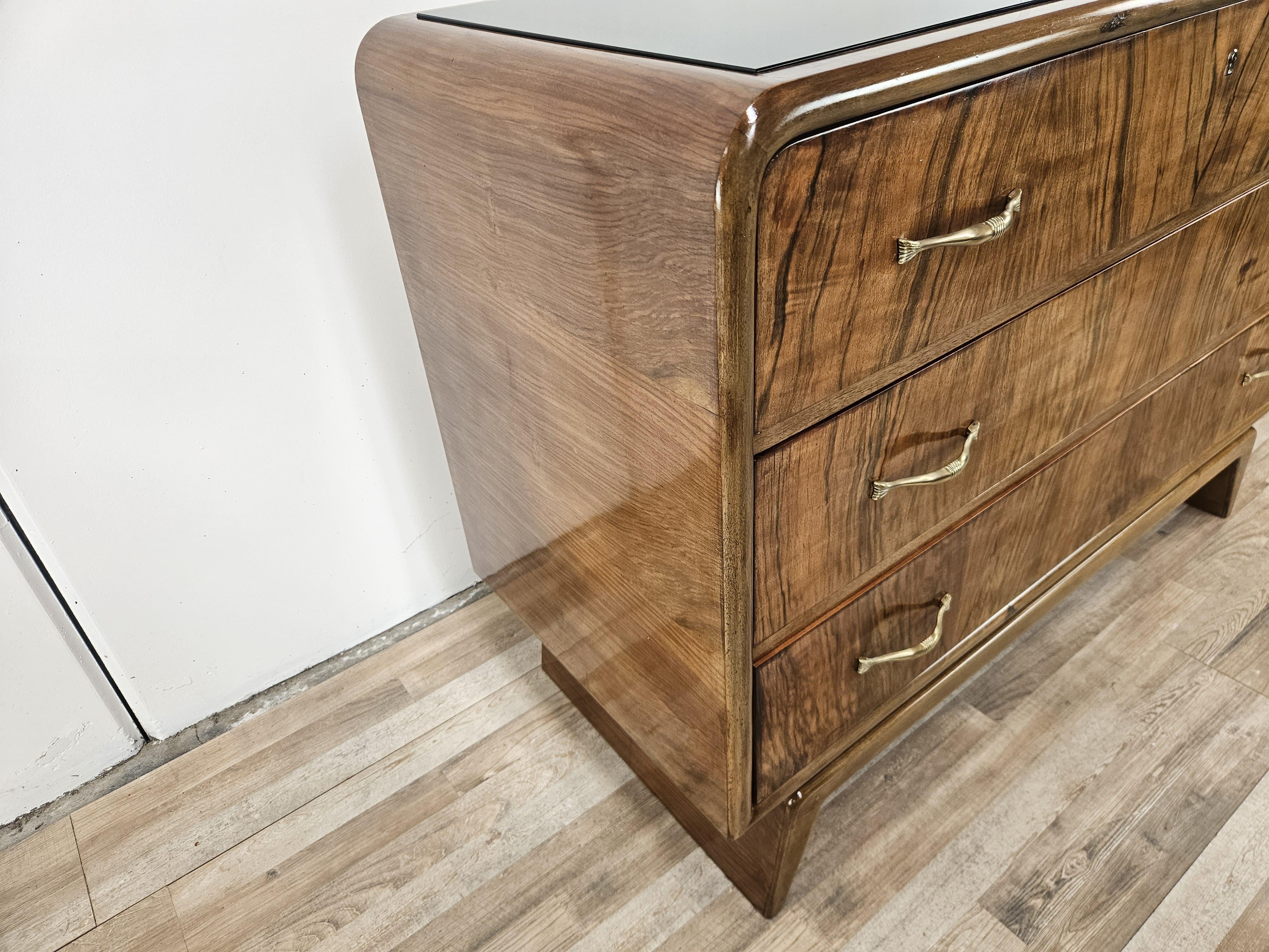 Italian Art Deco walnut burl dresser with black glass top and brass handles For Sale