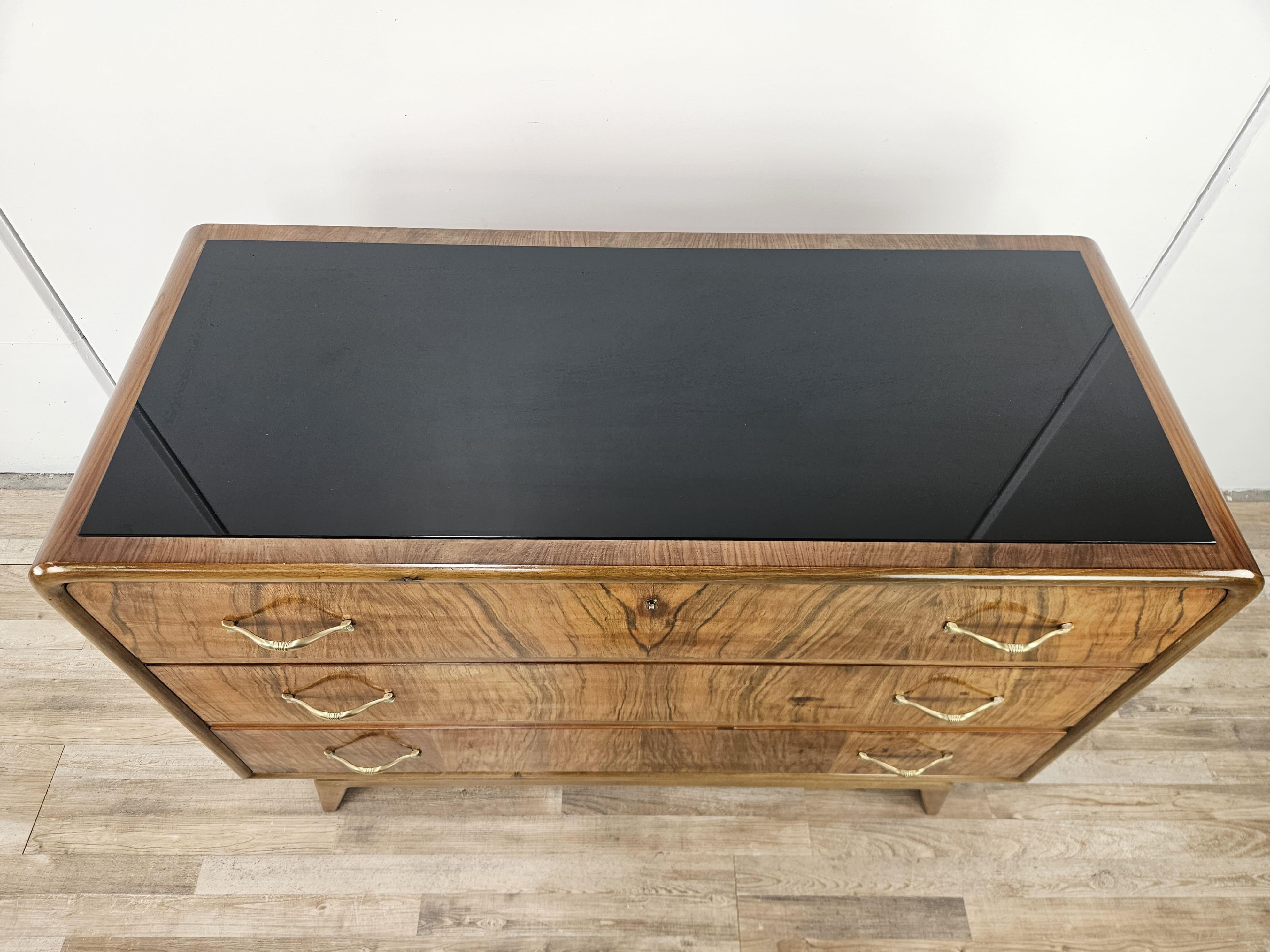 Veneer Art Deco walnut burl dresser with black glass top and brass handles For Sale