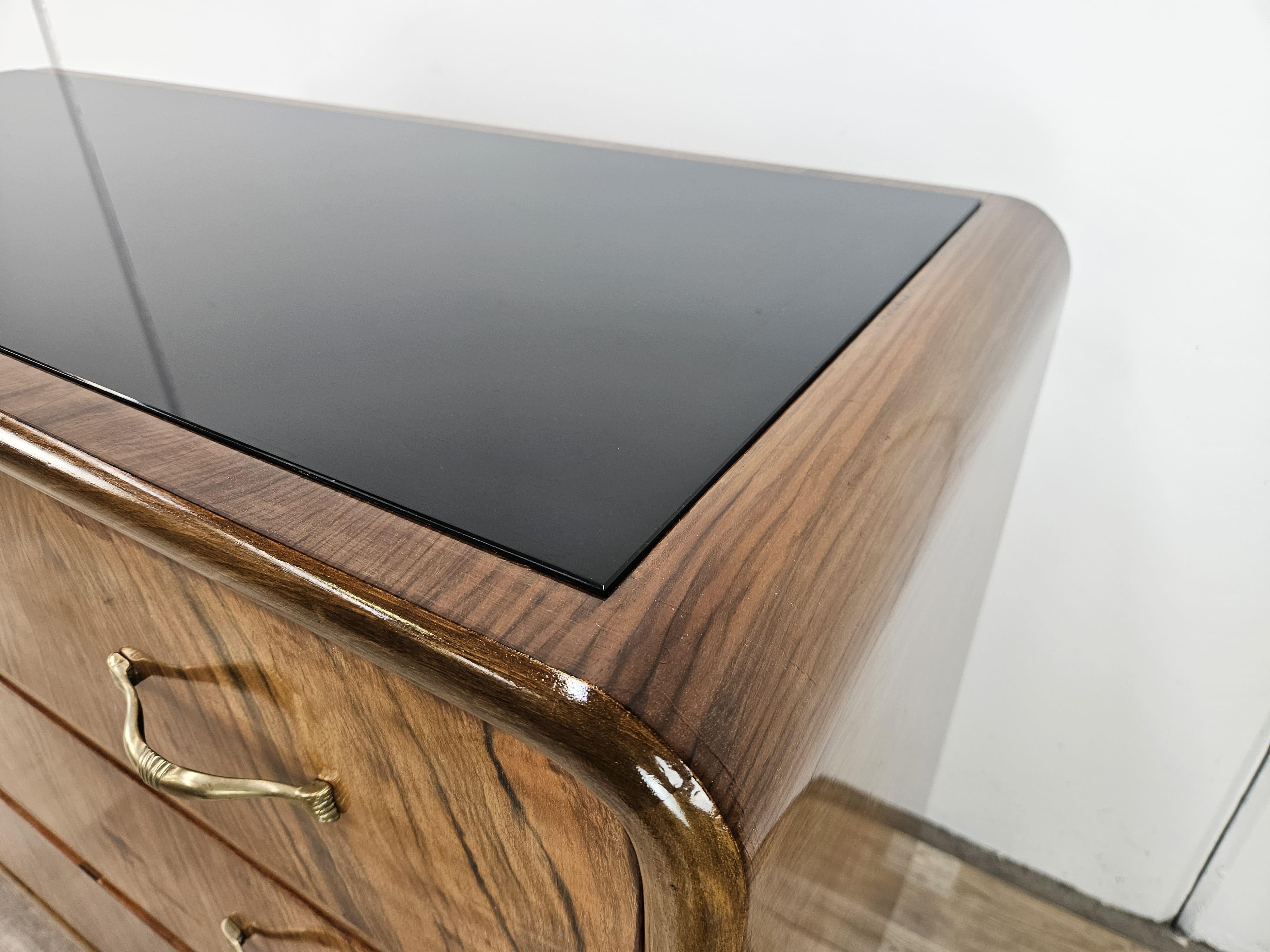 Mid-20th Century Art Deco walnut burl dresser with black glass top and brass handles For Sale