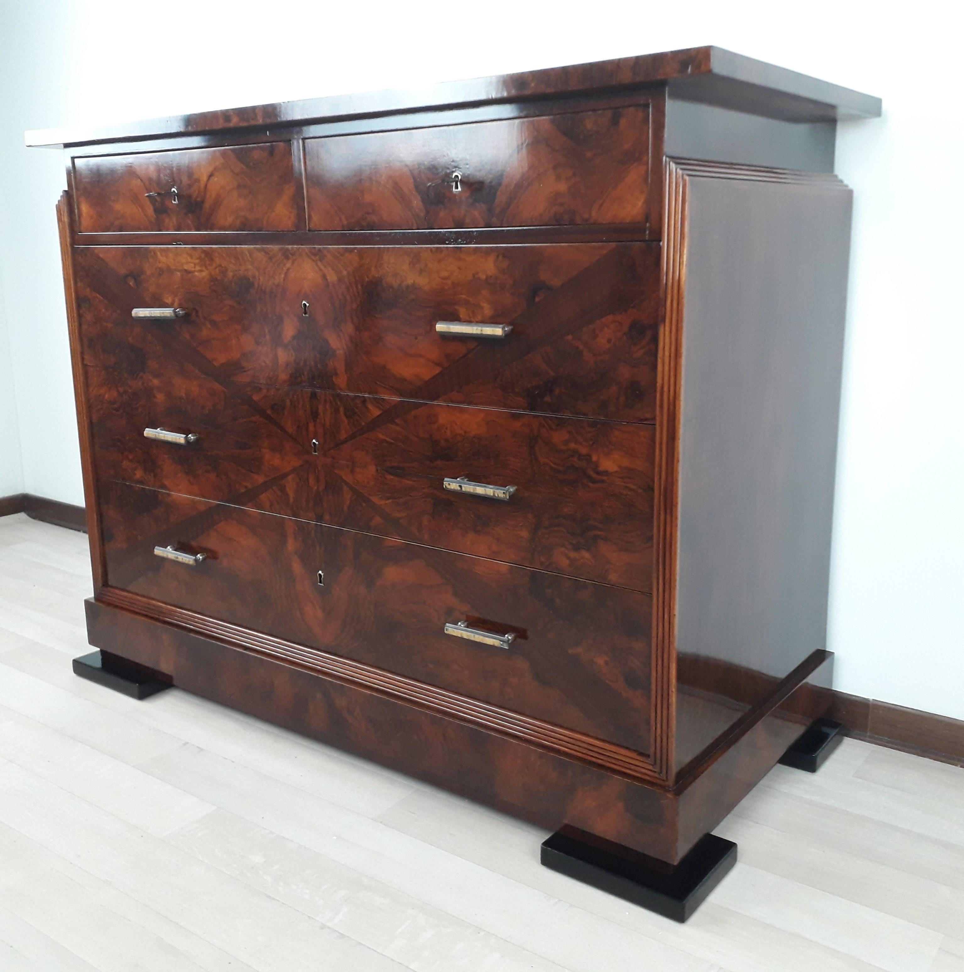 Spectacular Art Dèco Masonic Dresser made entirely of Walnut Burl with side profiles in Blonde Walnut striped.
Drawer fronts in Walnut Burl with St. Andrew's cross inlaid in Rosewood in three-dimensional form.
Original Brass and Bakelite 3-component