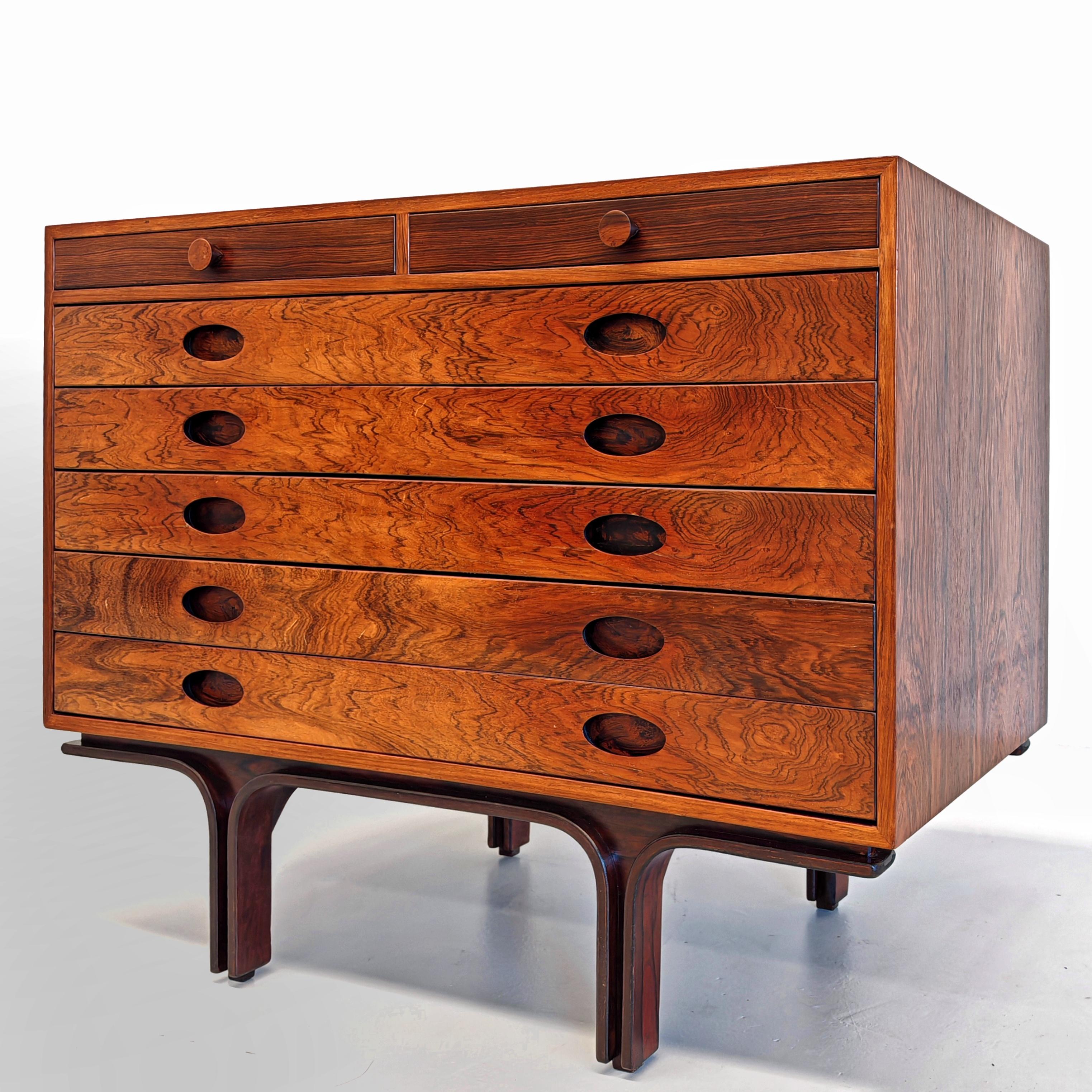 Stupenda cassettiera disegnata negli anni 50 da Gianfranco Frattini per Bernini. Il mobile è in legno esotico con particolarissime sfumature di colore e venature fiammate. Il mobile ha 5 cassetti grandi con altezza interna di 8 cm e 2 cassetti più