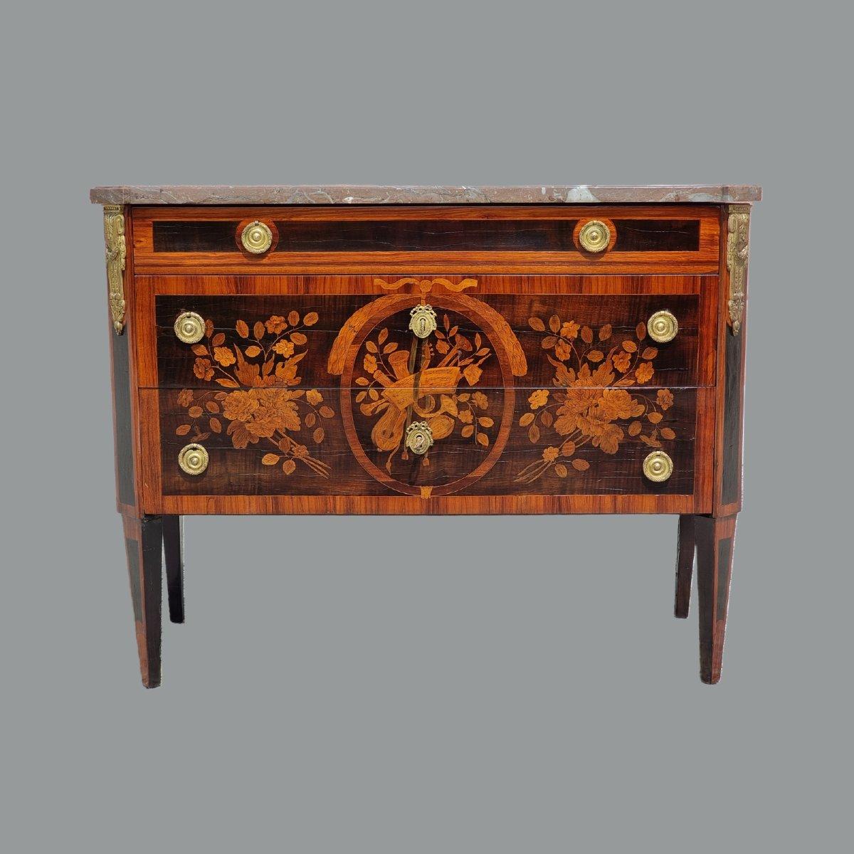 Elegante commode a tre cassetti (di cui uno superiore di dimensioni ridotte), realizzato in Francia nella seconda metà del XVIII secolo, firmato sotto il piano in marmo da P. Pioniez, maestro ebanista attivo a Parigi, ricevuto maestro nel 1765 e