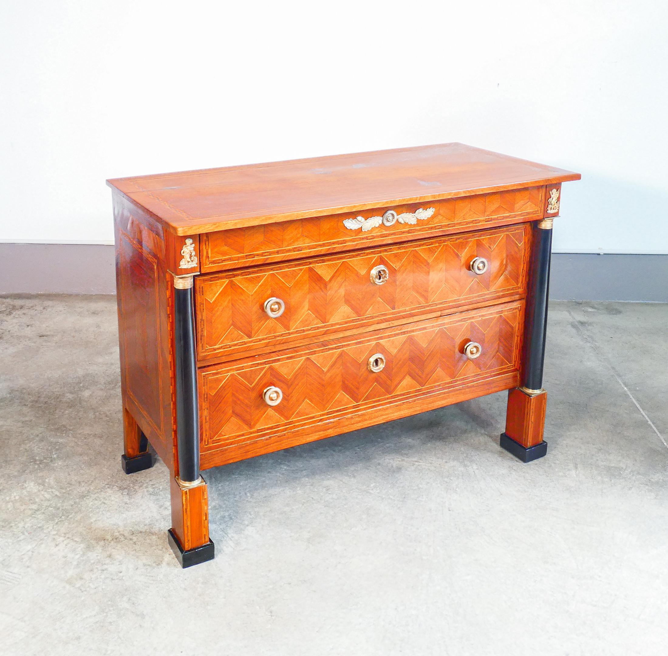 Comò IMPERO
originale d'epoca,
in legno di noce
intarsiato ed ebanizzato.

PERIODO
Prima metà
dell'Ottocento

MODELLO
Comò cassettone
a tre cassetti

MATERIALI
Legno di noce intarsiato,
colonne e piedini ebanizzati.
Dettagli in