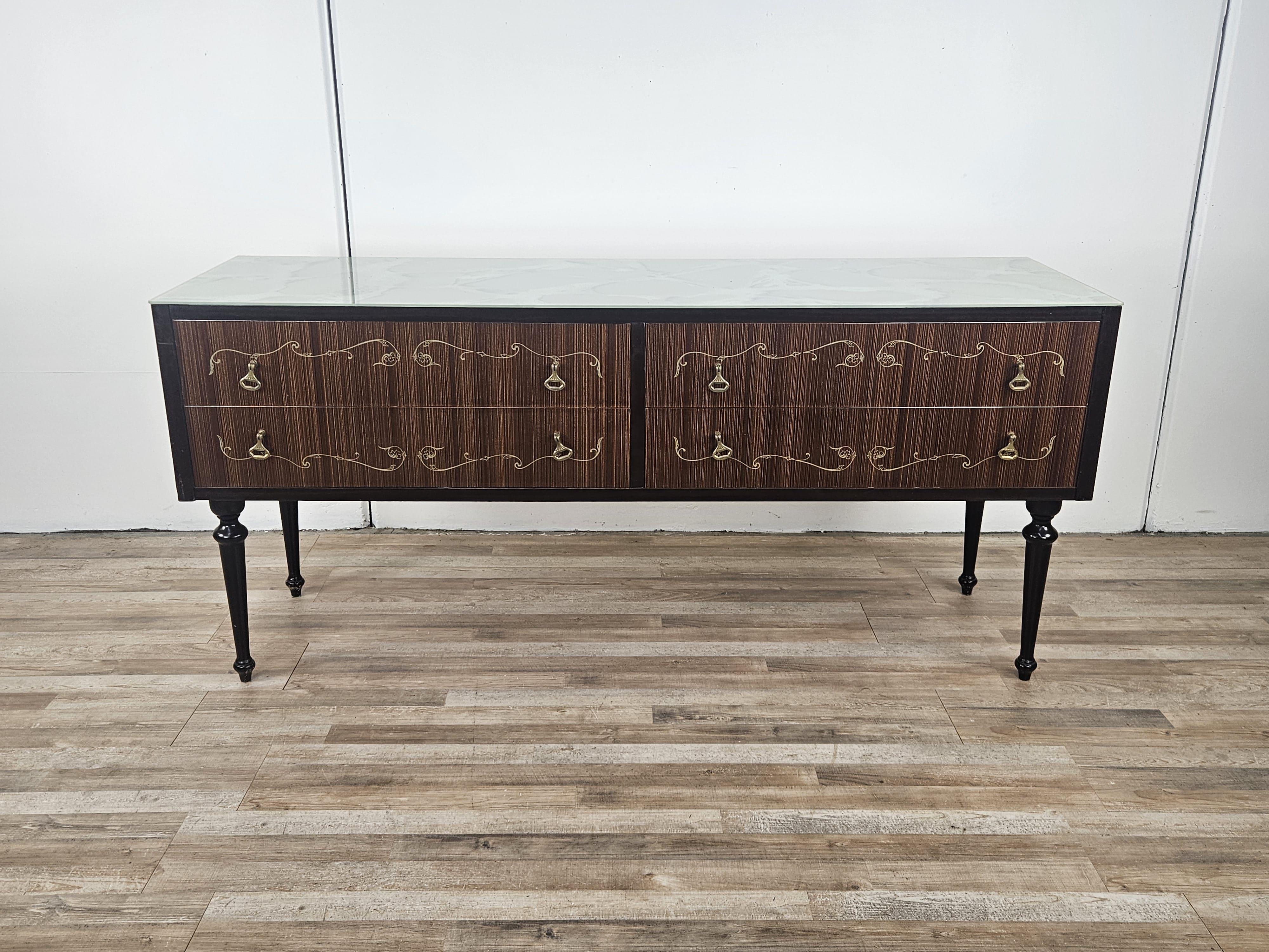 Italian cabinet with four large drawers decorated with brass handles and workmanship along the fronts.

Note the beautiful blue processed glass top.

Normal signs due to age and use as pictured.