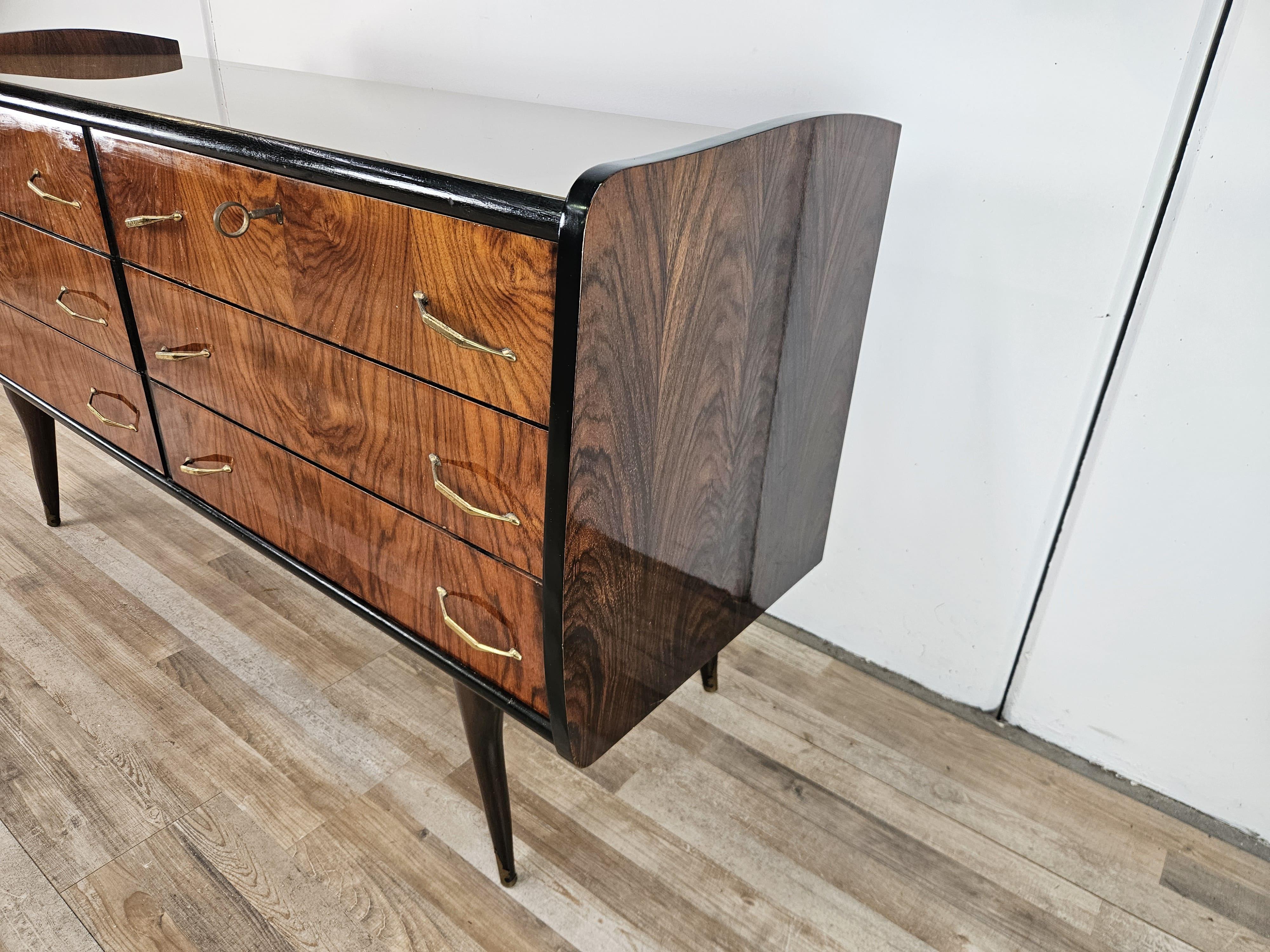 Cassettiera anni '50 interamente rivestita in radica con profili ebanizzati, arricchita da maniglie in ottone e decori sulle punte delle gambe.

Può essere utilizzata in soggiorno in corridoio o in camera da letto come comò.

Il vetro è originale