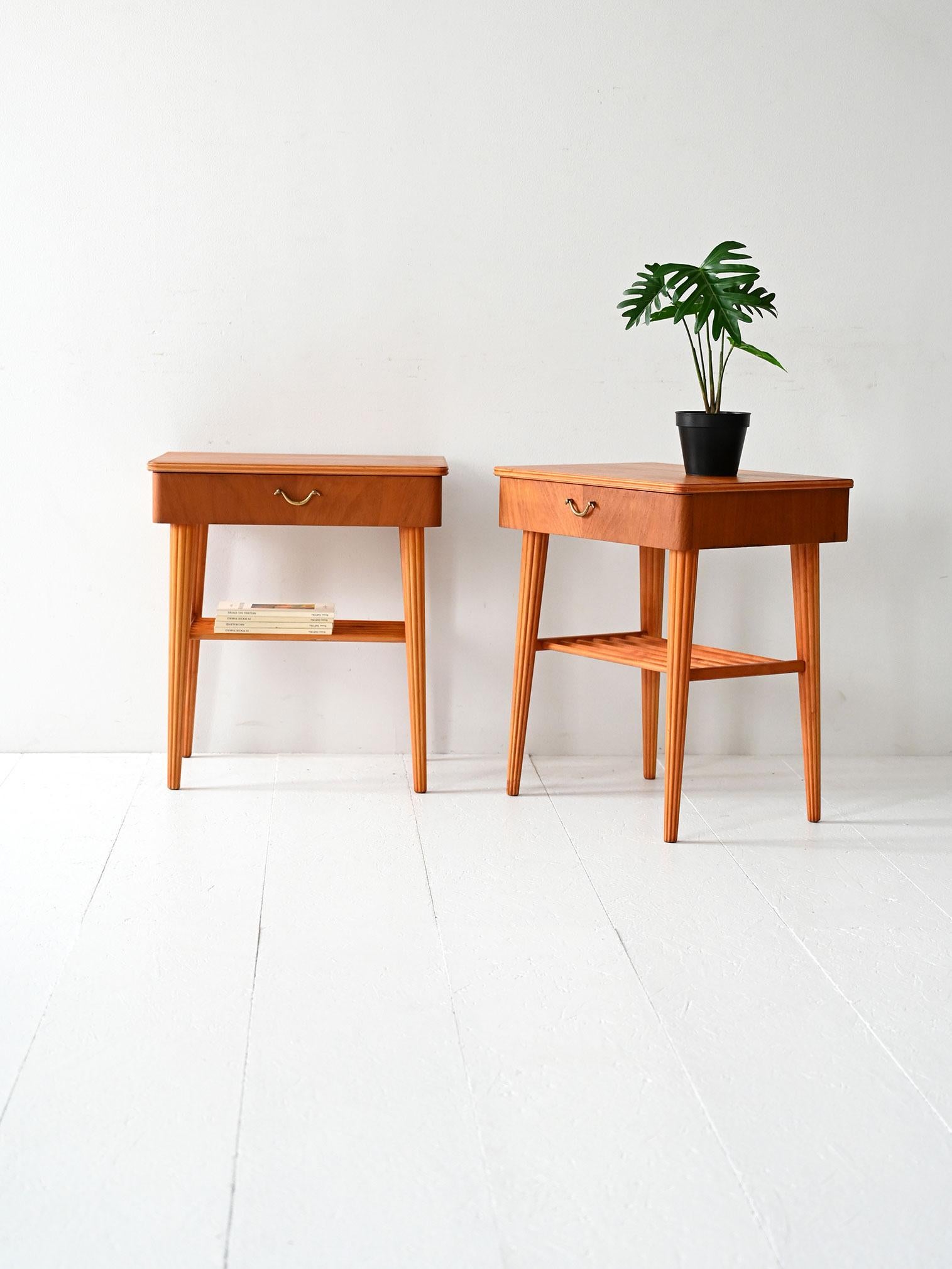 Élégante paire de tables de chevet suédoises avec tiroir, étagère à lattes et détails sculptés. 

Paire de tables de chevet danoises des années 1940/50 en acajou avec des détails en bouleau. Les pieds fuselés et rainurés apportent de la légèreté à