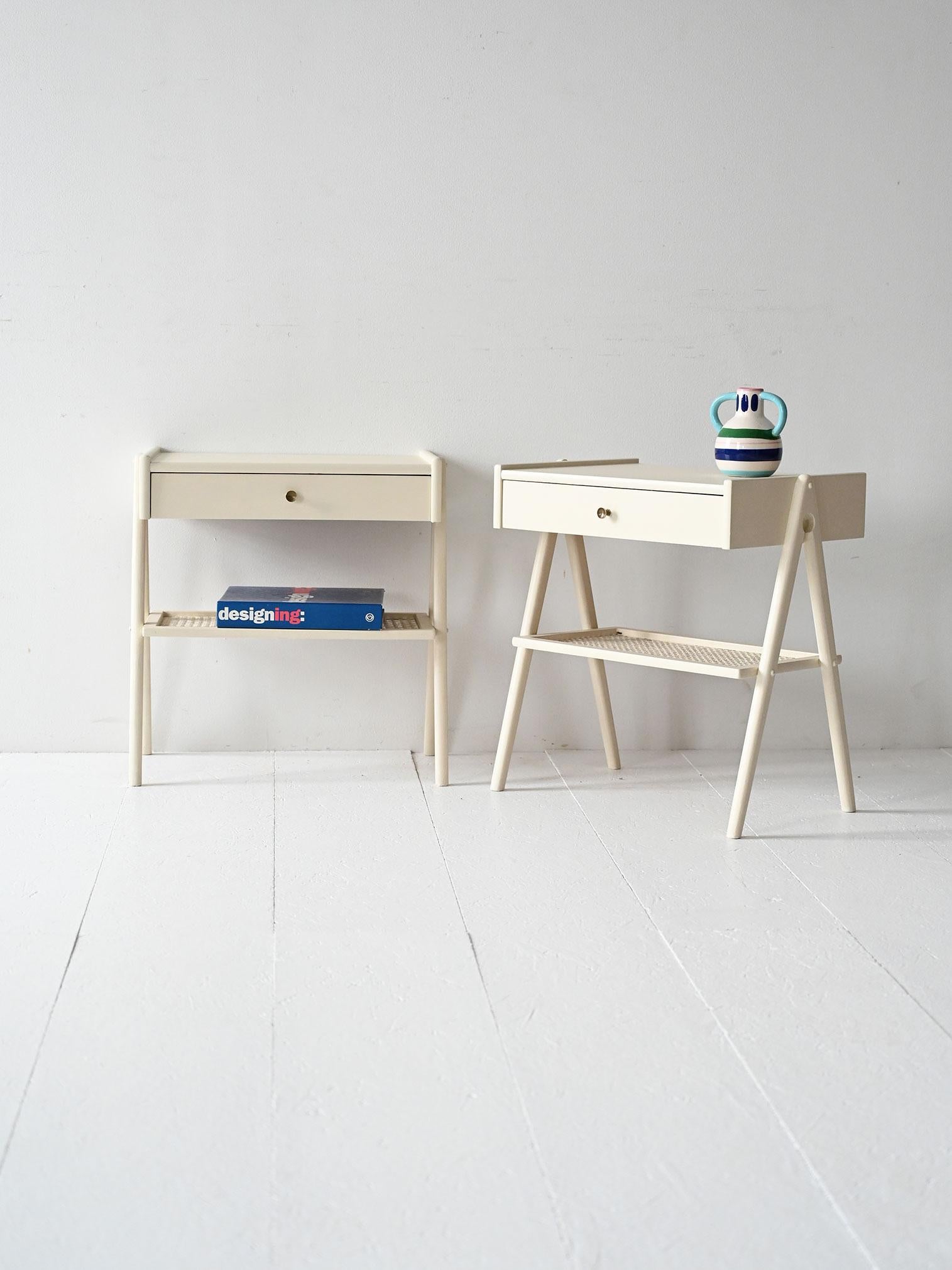 Coppia di comodini vintage scandinavi in legno laccato bianco con cassetto e ripiano in paglia di Vienna verniciata.

Coppia di comodini scandinavi anni ’60 in legno laccato bianco. Ogni pezzo è dotato di un cassetto con maniglia in ottone e di una