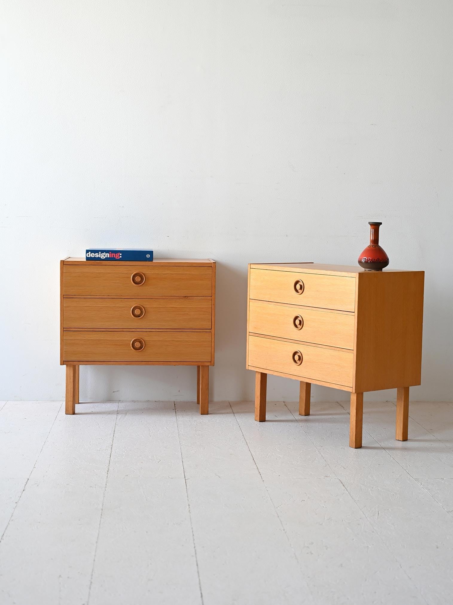 Coppia di comodini anni '60 con tre cassetti e pomelli in legno scolpito.

Si distinguono per le linee squadrate e la presenza dei tre capienti cassetti. 
Buone condizioni. Potrebbero presentare dei segni del tempo. Per piacere presta attenzione