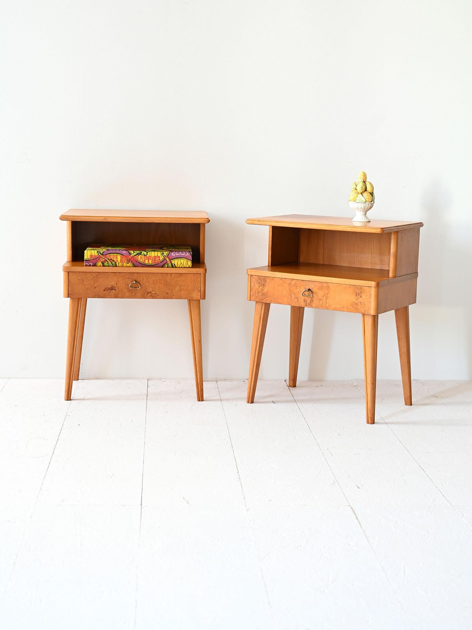 Paire de tables de chevet vintage qui font écho au style et au goût du design nordique du milieu du siècle dernier. Composées d'une double étagère, elles sont équipées d'un tiroir avec une poignée en métal doré. 

Le tiroir en bois de bruyère met en