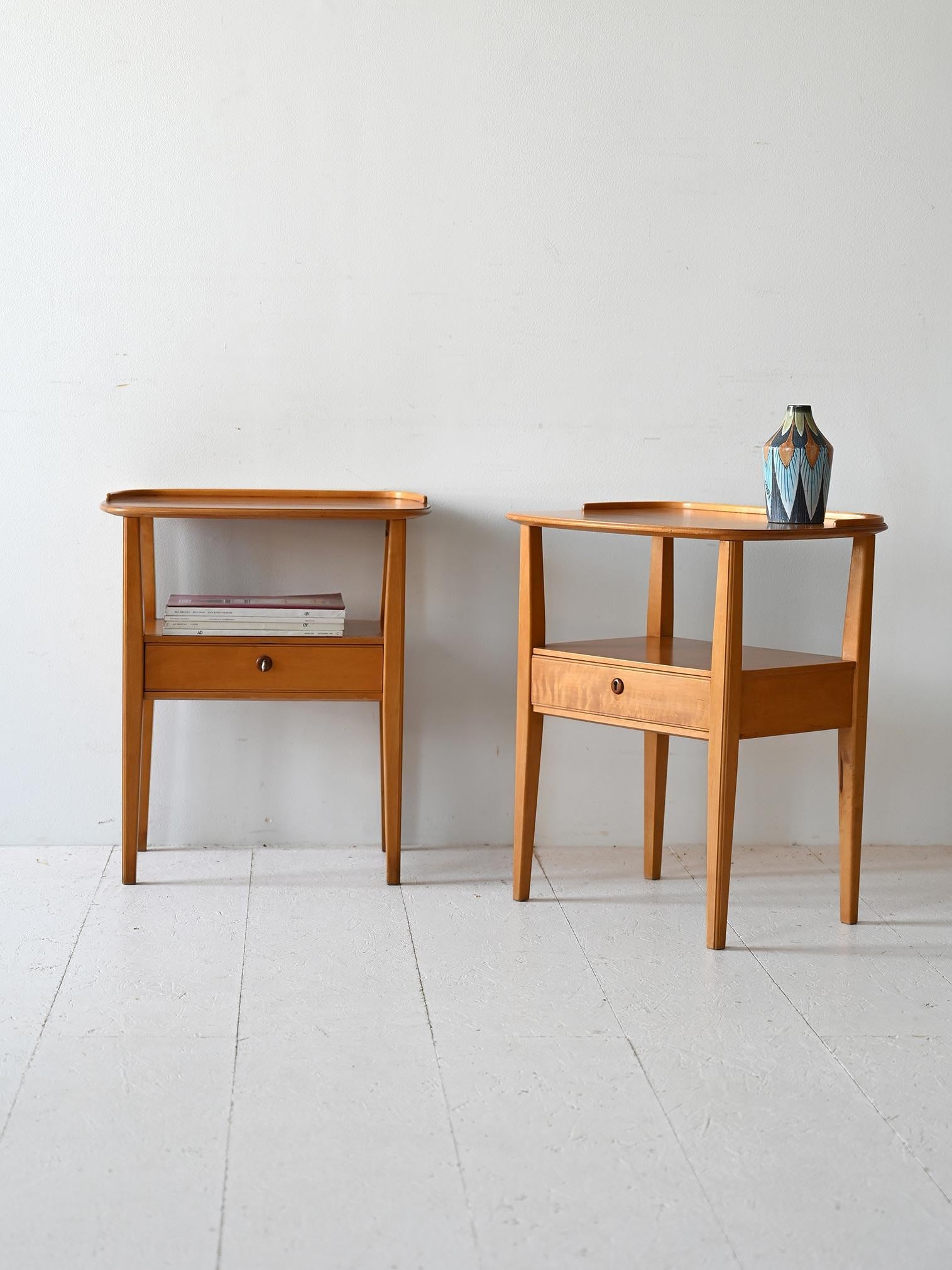 Coppia di comodini scandinavi con piano tondeggainte sotto il quale si trova un ripiano dotato di cassetto. 

Un pezzo di modernariato originale e funzionale, ideale per arredare la camer da letto con un tocco retrò. Buone condizioni. Potrebbe