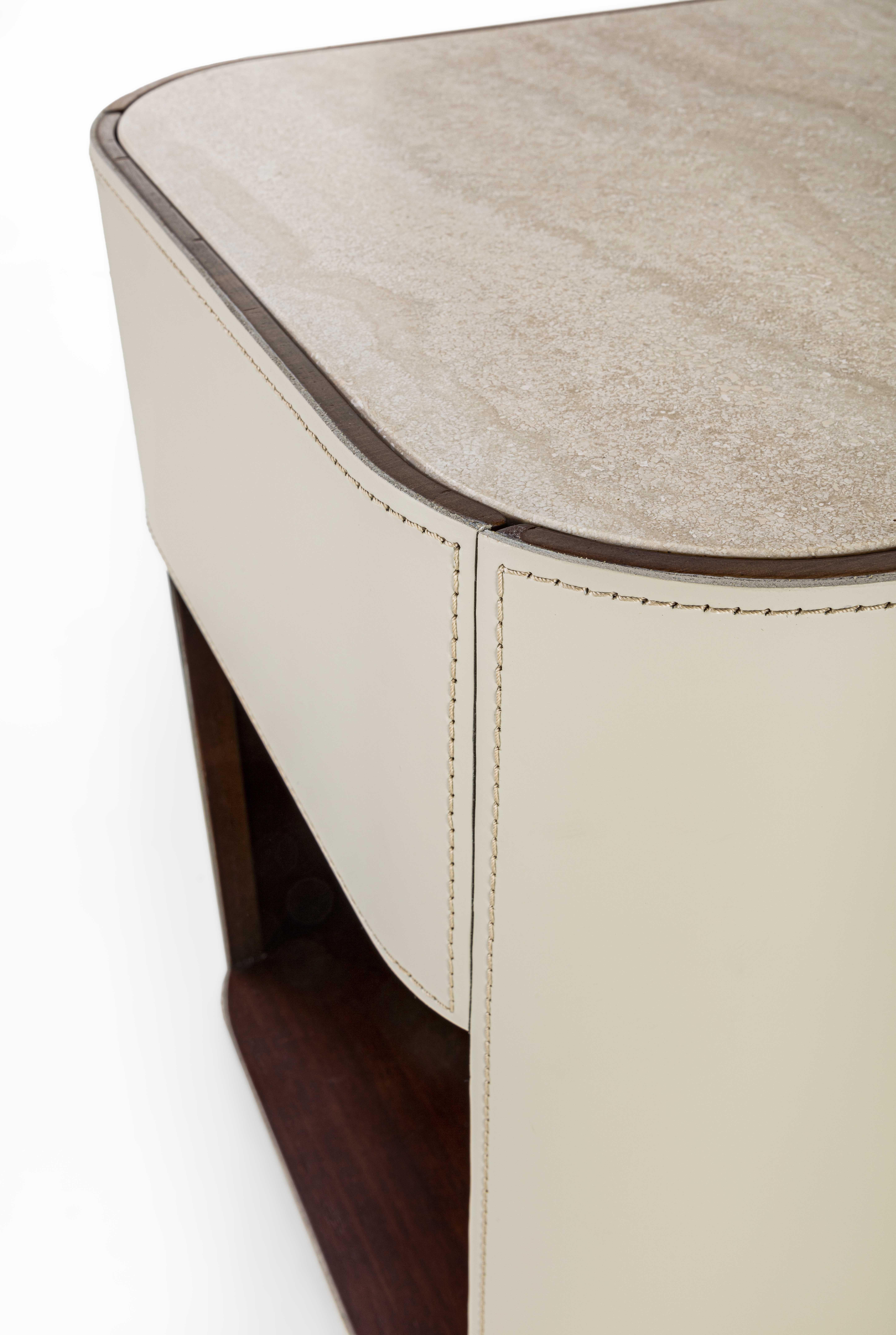Nightstand with simple, rounded lines, covered externally in leather with visible stitching and embellished with a matte Travertine marble top. It features a shelf and a drawer with a rallenty system. Canaletto Walnut F105 interior.
Realizable in