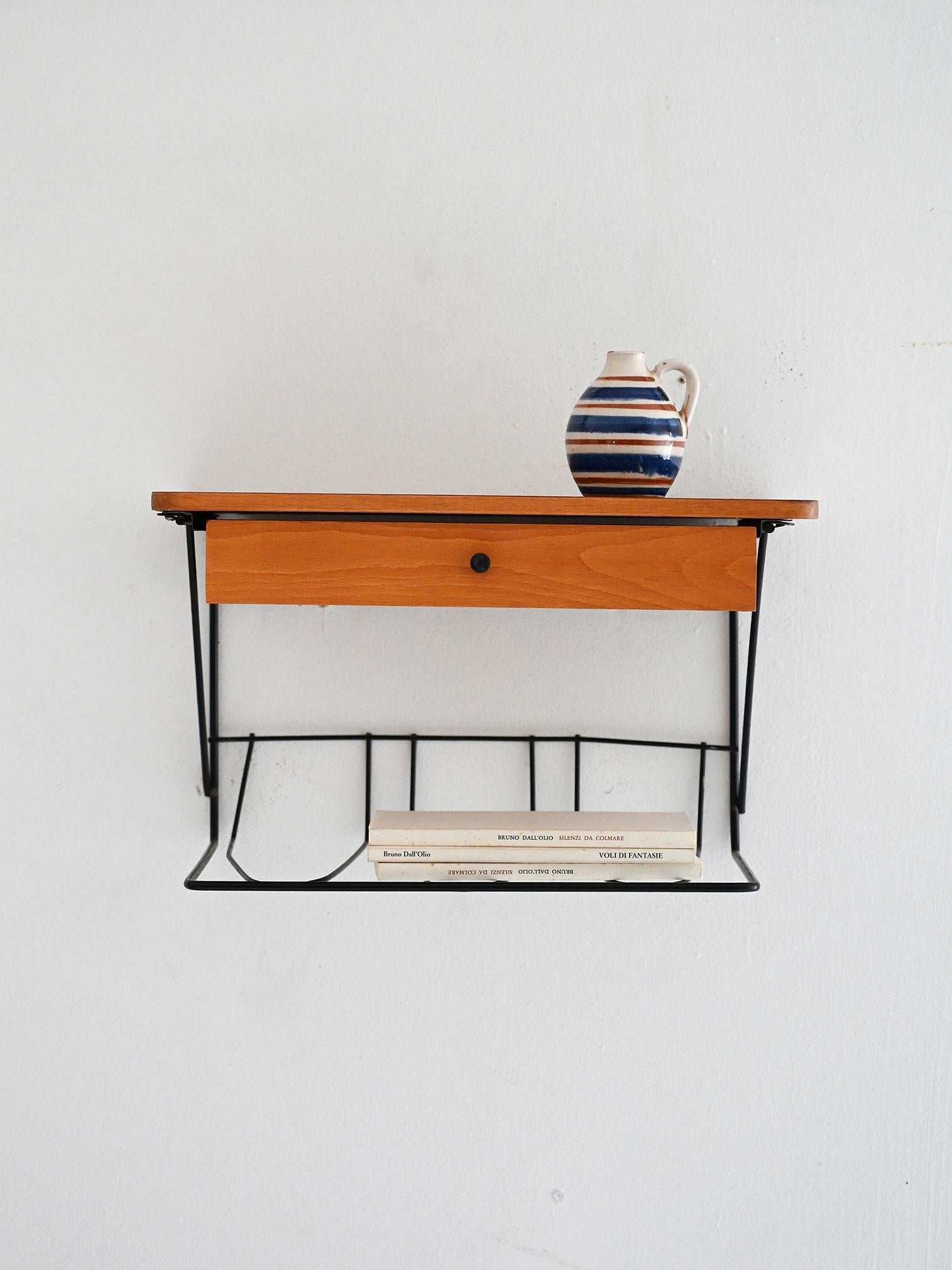 Table de chevet murale scandinave des années 1960 avec plateau et tiroir en teck, porte-revues en métal noir et poignée en bakélite noire.

Élégante table de chevet murale scandinave des années 1960, avec un cadre en métal peint en noir, un plateau