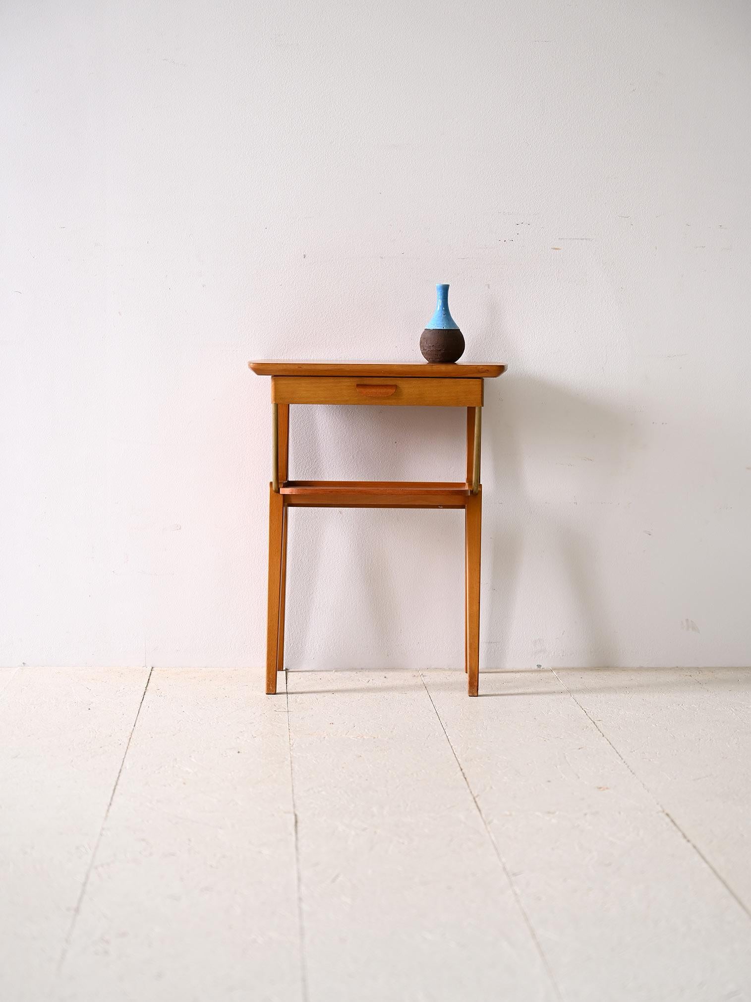 Skandinavischer modernistischer Nachttisch im Vintage-Stil.

Der geschnitzte Griff an der Schublade verleiht dem Design eine künstlerische Note, während die goldenen Metalldetails, wie die beiden Rohrstangen, die die Beine mit dem Regal verbinden,