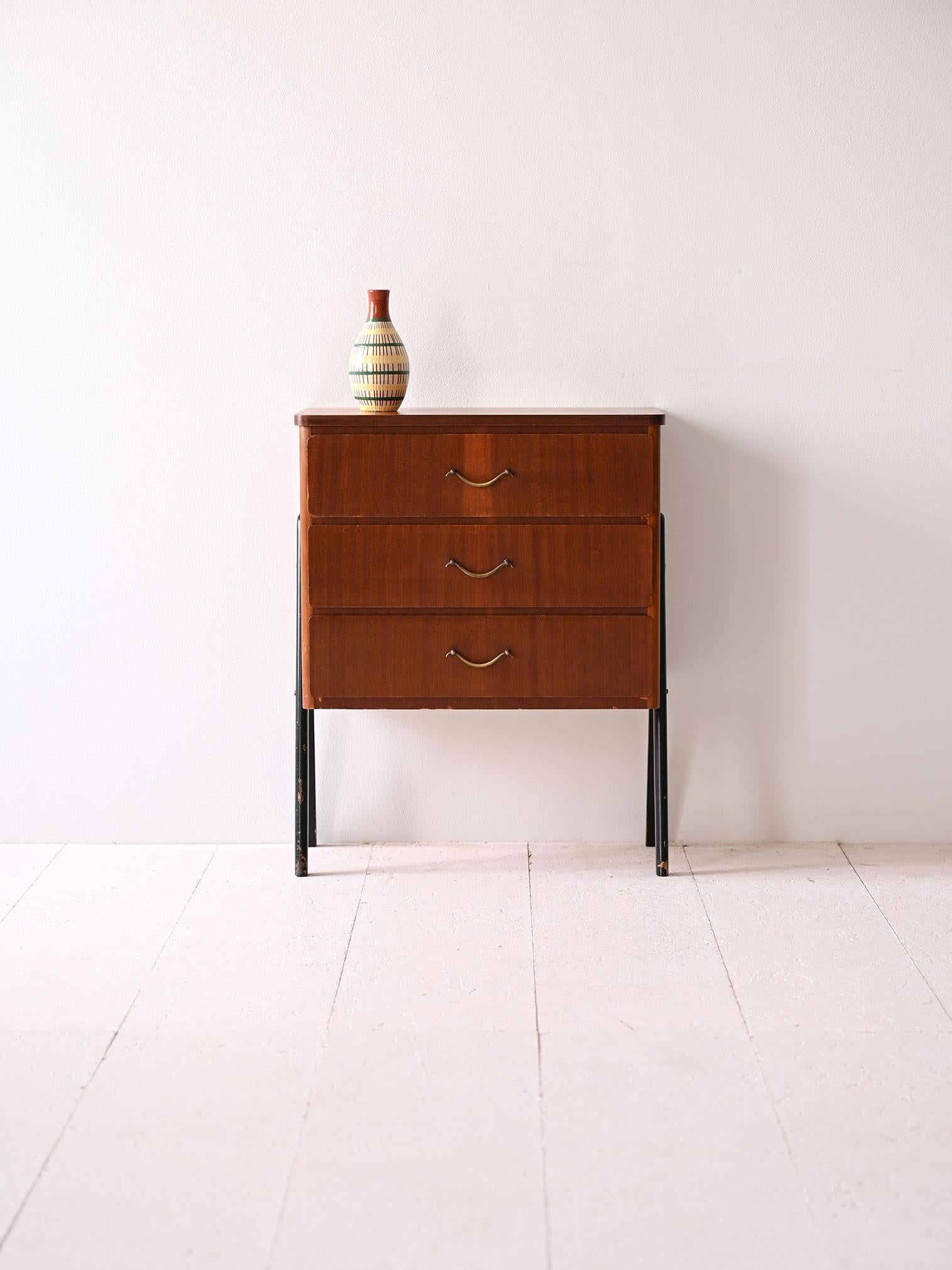 Small vintage mahogany chest of drawers with three drawers and gold metal handles. The black legs give it a modern and light appearance. 

A versatile and refined piece, perfect for use as a nightstand or entryway cabinet. 
The practical and