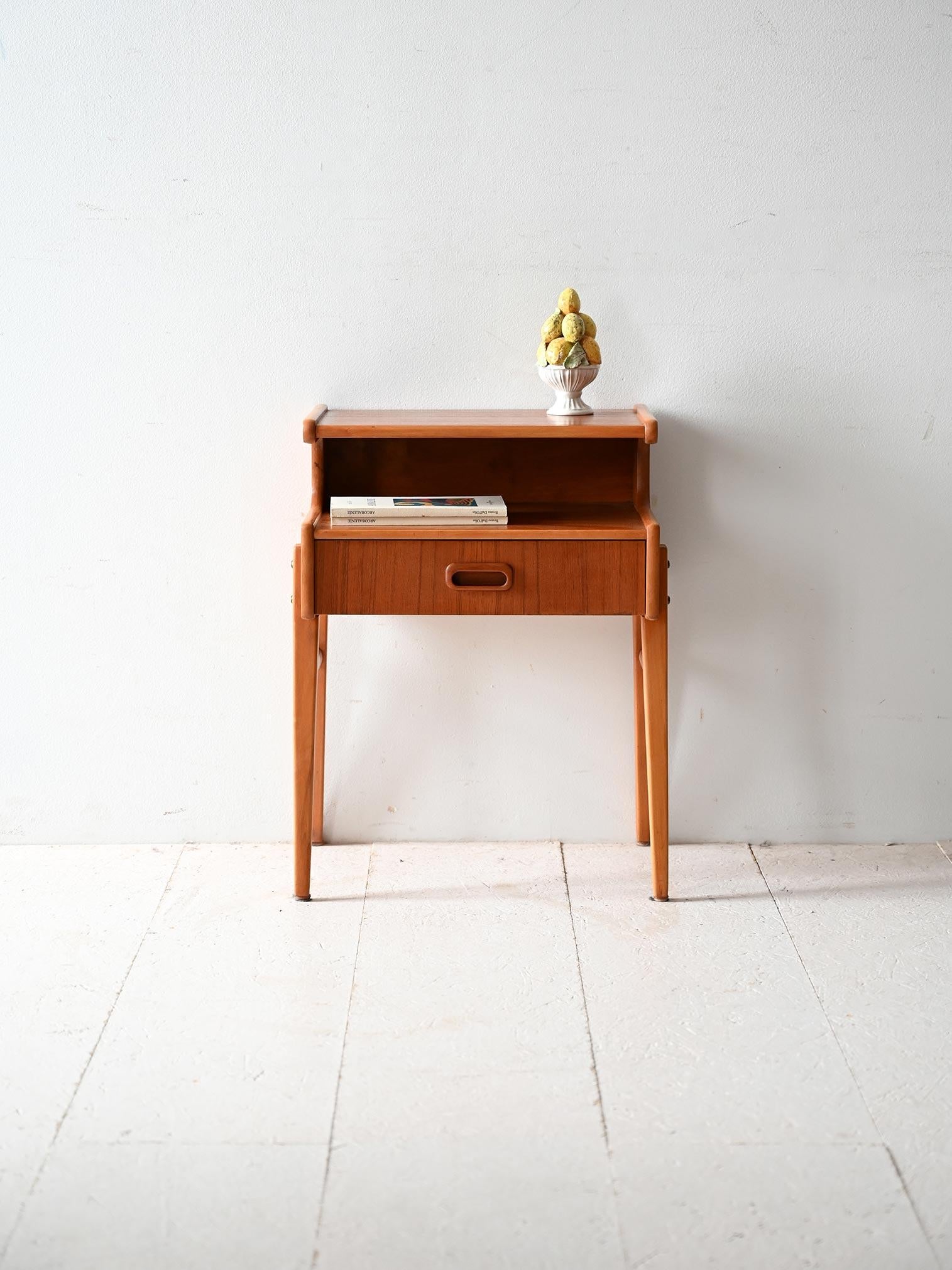 Comodino scandinavo vintage anni ’50 in teak, con cassetto, mensola superiore e linee sobrie tipiche del design nordico.

Comodino scandinavo anni ’50 in teak, caratterizzato da un cassetto con maniglia incassata e una mensola superiore che consente