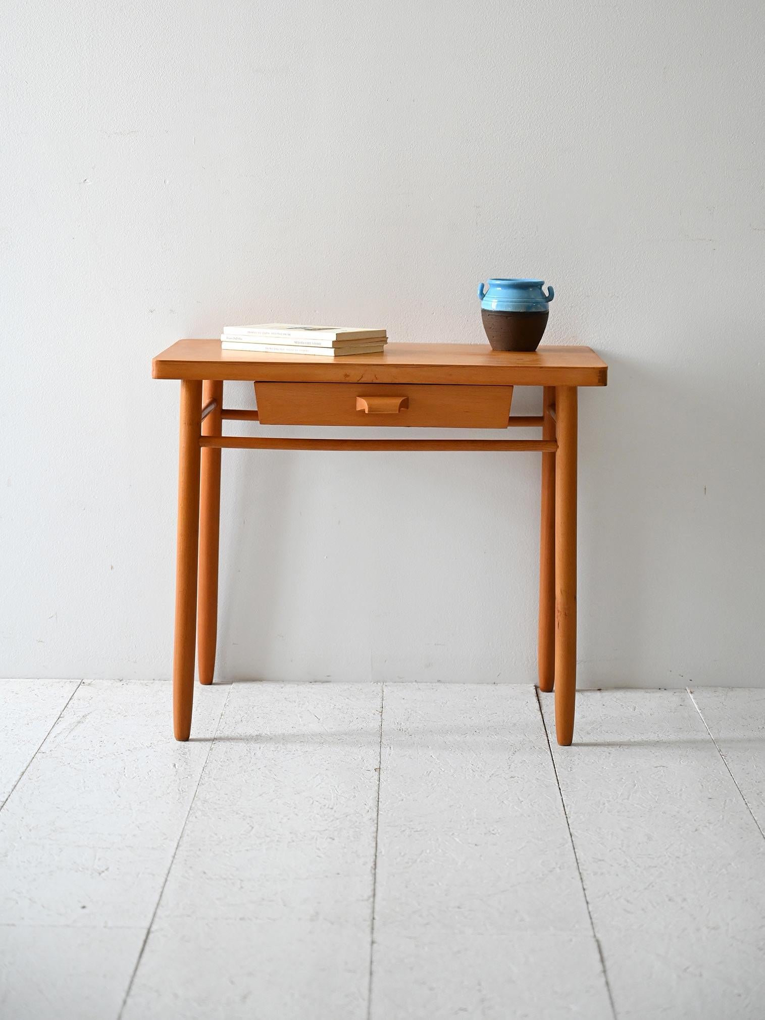 Comodino vintage in faggio con cassetto centrale e struttura leggera dal design essenziale.

Comodino scandinavo originale anni ’60 in legno di faggio, dal design sobrio e proporzionato. Il piano rettangolare poggia su gambe affusolate collegate da