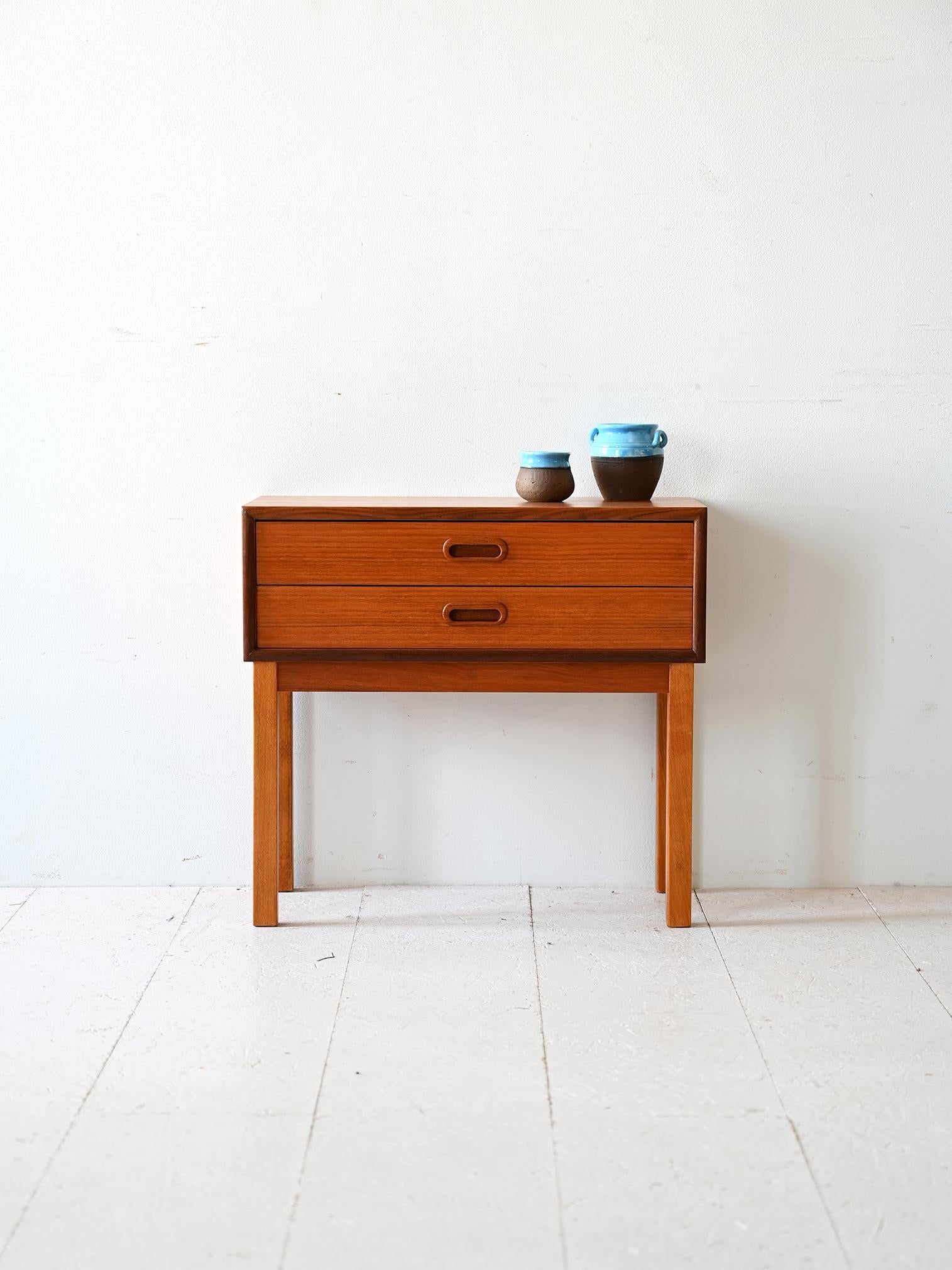 1960s teak nightstand with rectangular top and square legs. There are two drawers with the handle carved in wood. 

A vintage furniture piece with modern lines, ideal both as a bedside table and as an entryway or bathroom cabinet. 
Good conditions.