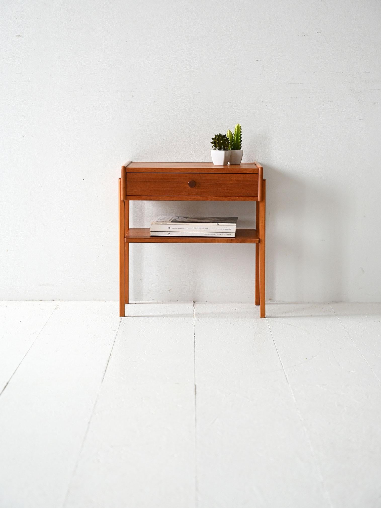 Table de chevet vintage en teck avec tiroir et étagère. Des lignes géométriques, une structure solide et un style scandinave essentiel.

Table de chevet scandinave en teck des années 1950/60 avec cadre en bois massif et pieds extérieurs. Le design