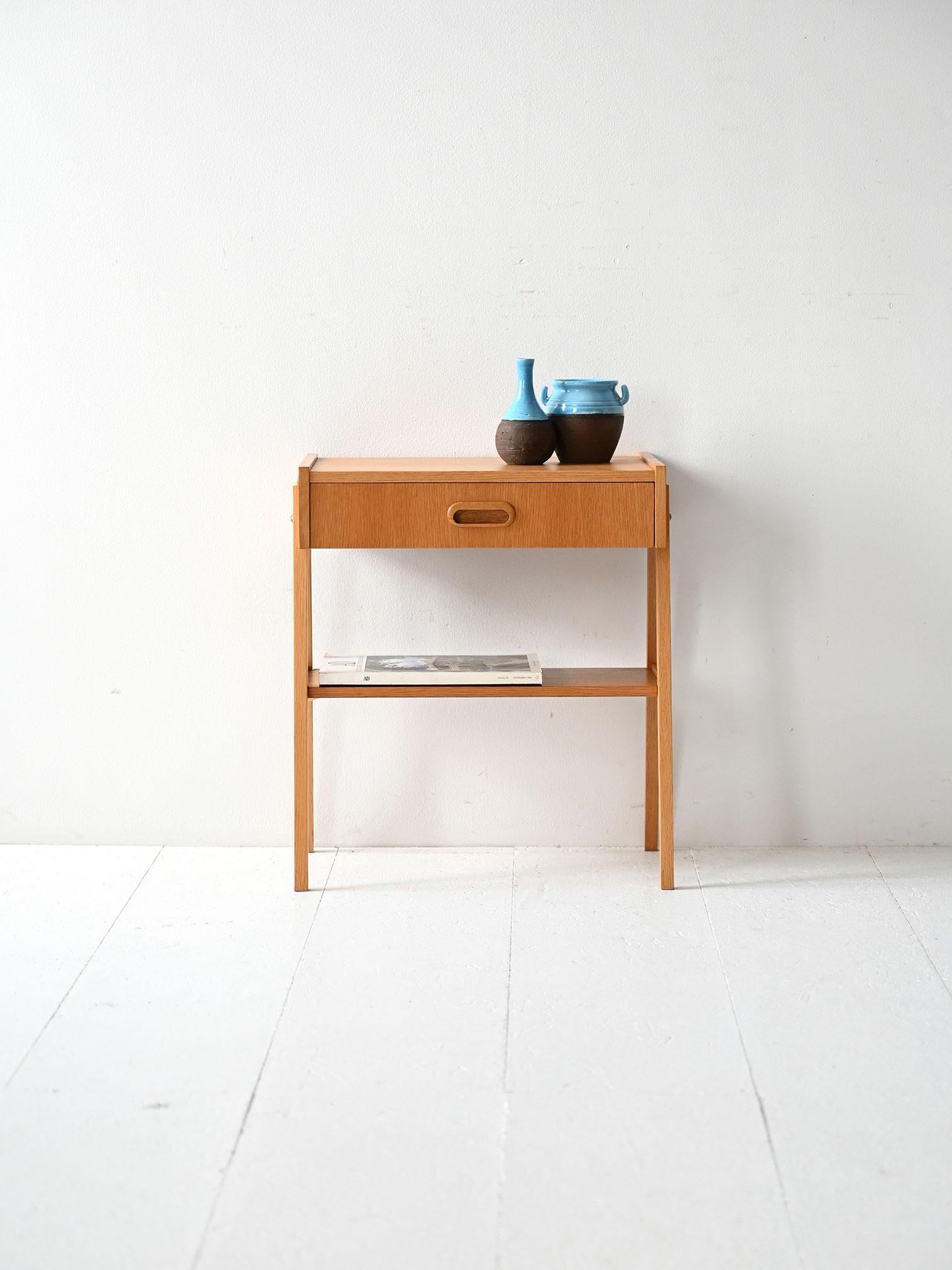 Table de chevet en teck avec tiroir à poignée encastrée, pieds obliques et détails structurels en laiton apparent.

Original table de chevet scandinave en teck des années 1960. La structure présente une géométrie essentielle avec des pieds obliques