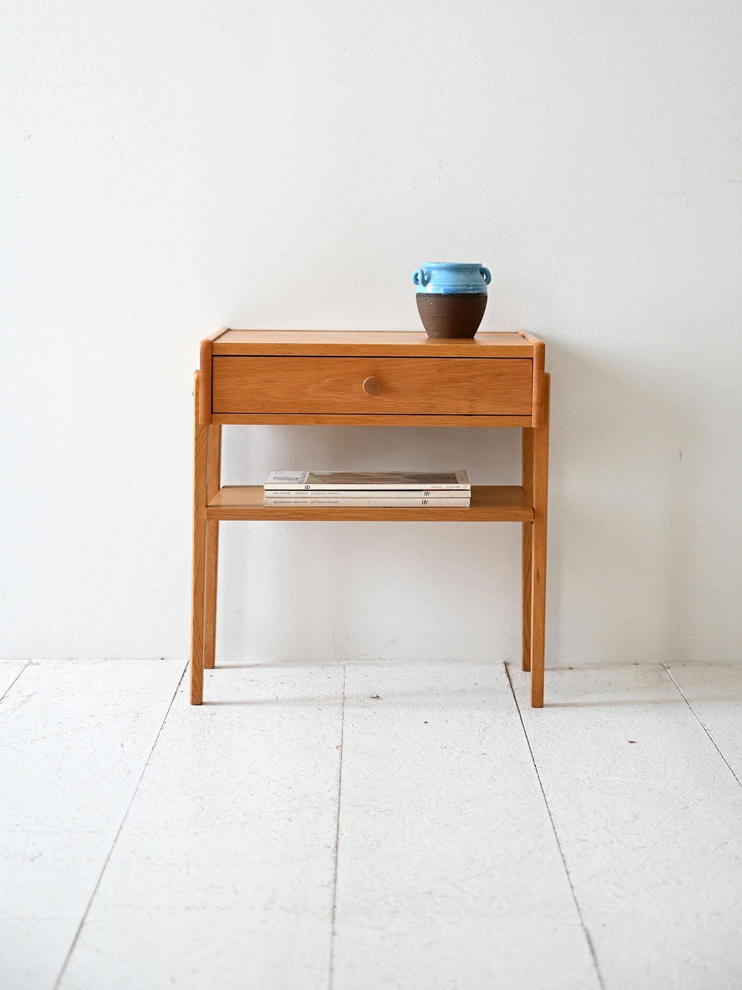 Comodino scandinavo fine anni ’50 in rovere, con cassetto a pomello e mensola inferiore. Struttura sobria e leggera.

Comodino scandinavo vintage realizzato in rovere chiaro, risalente alla fine degli anni ’50 o primi anni ’60. La struttura è