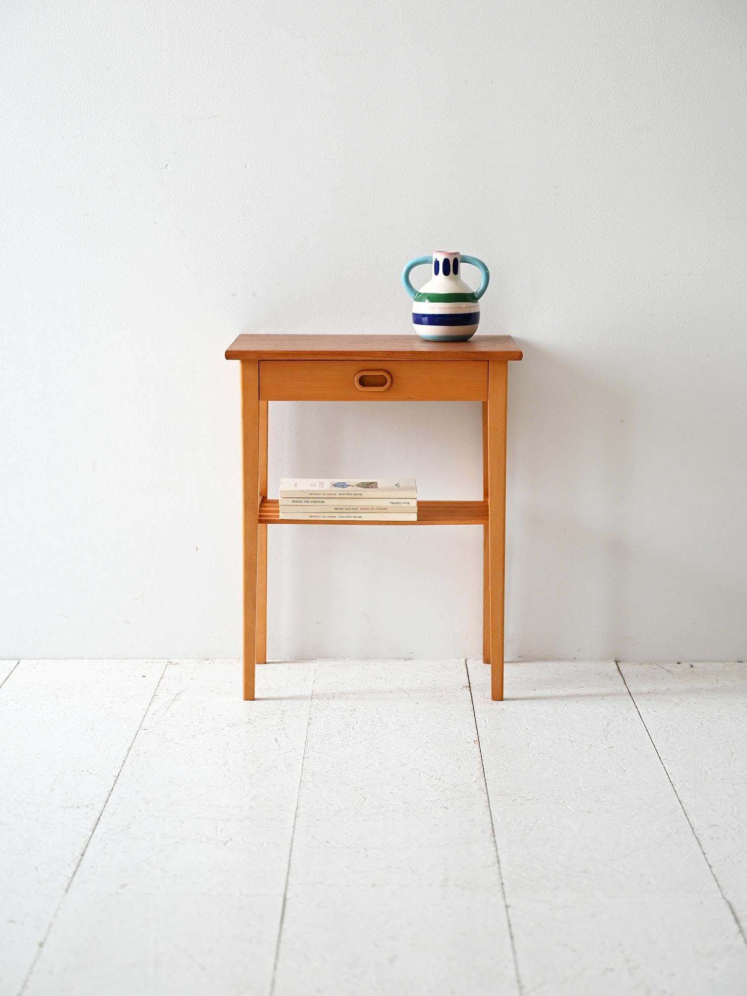 Comodino anni ’60 in rovere, con cassettino a incasso e mensola bassa a doghe.

Comodino scandinavo originale degli anni ’60 in rovere chiaro. Struttura essenziale con cassettino dal frontale incassato e maniglia integrata. Sotto è presente una