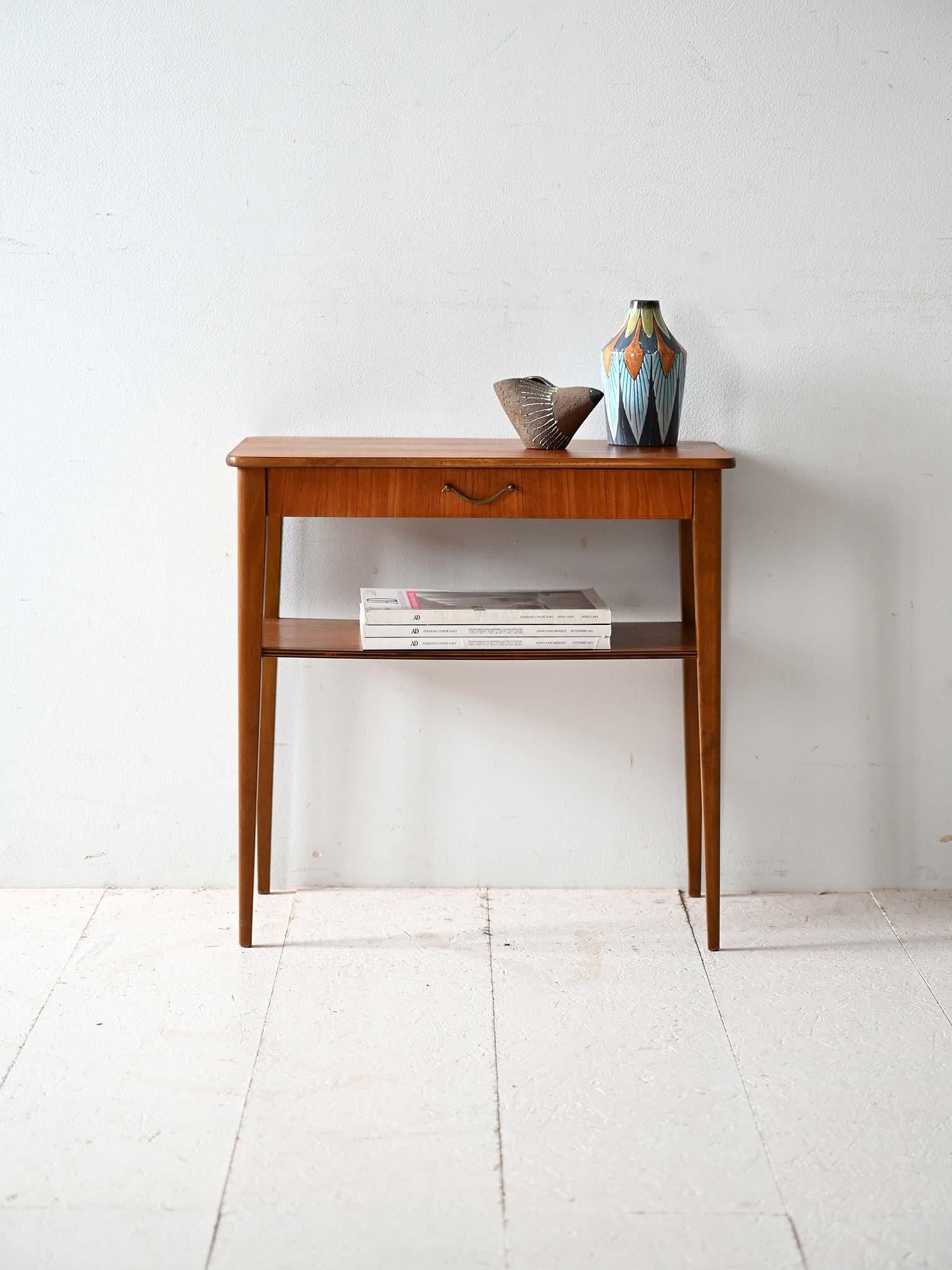 Comodino scandinavo vintage in teak anni ’50/’60, produzione Björkås Möbelfabrik, con mensola, gambe affusolate e maniglia in ottone.

Comodino scandinavo anni ’50/’60 realizzato in teak, prodotto da Björkås Möbelfabrik in Svezia. Struttura