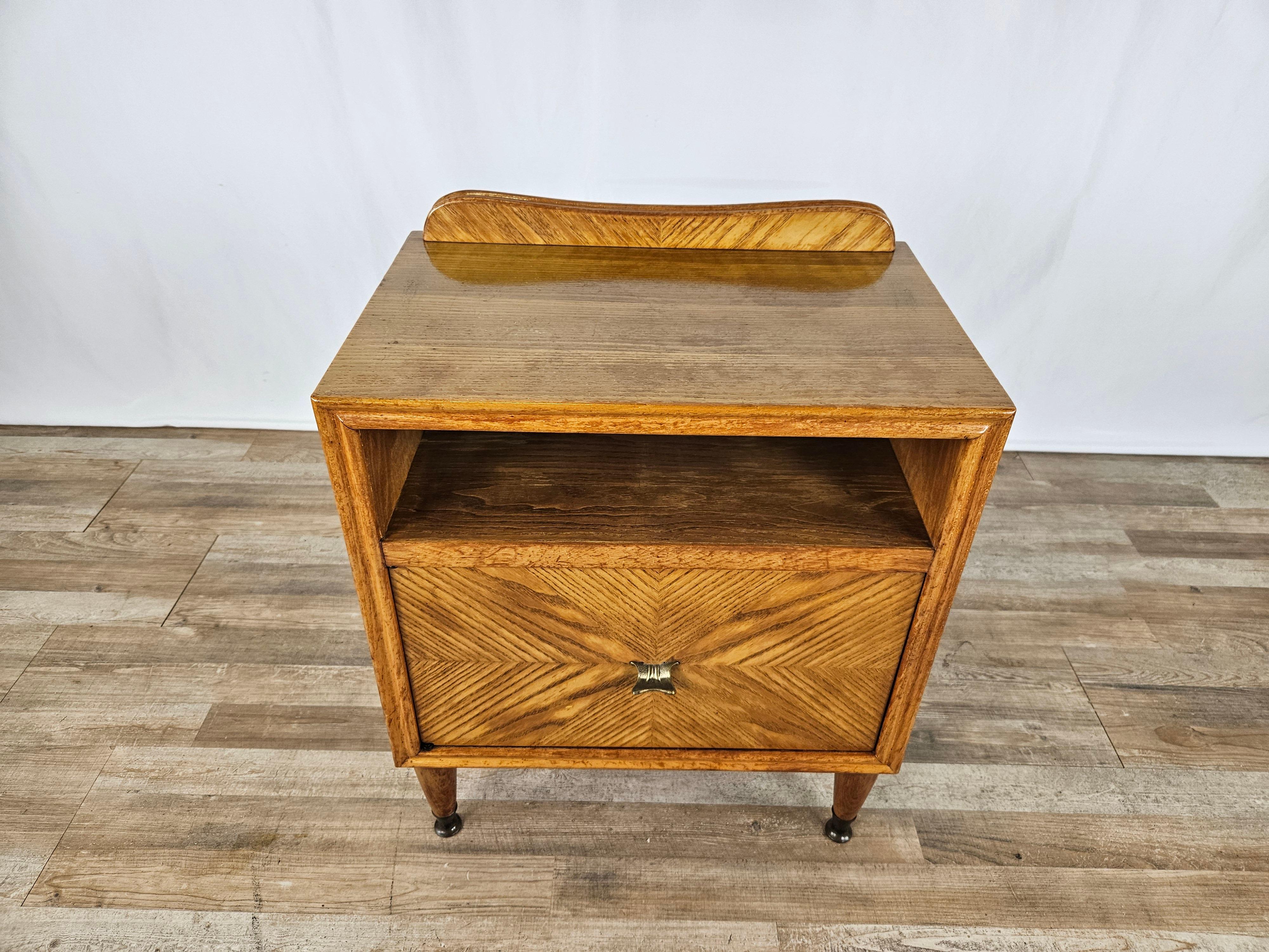 Early 1950s single bedside table in blond walnut with brass foot rails and central flap.

Modern and contemporary design element with square and linear measurements that make it placeable in any furnishing context.

Flap and upper open space.