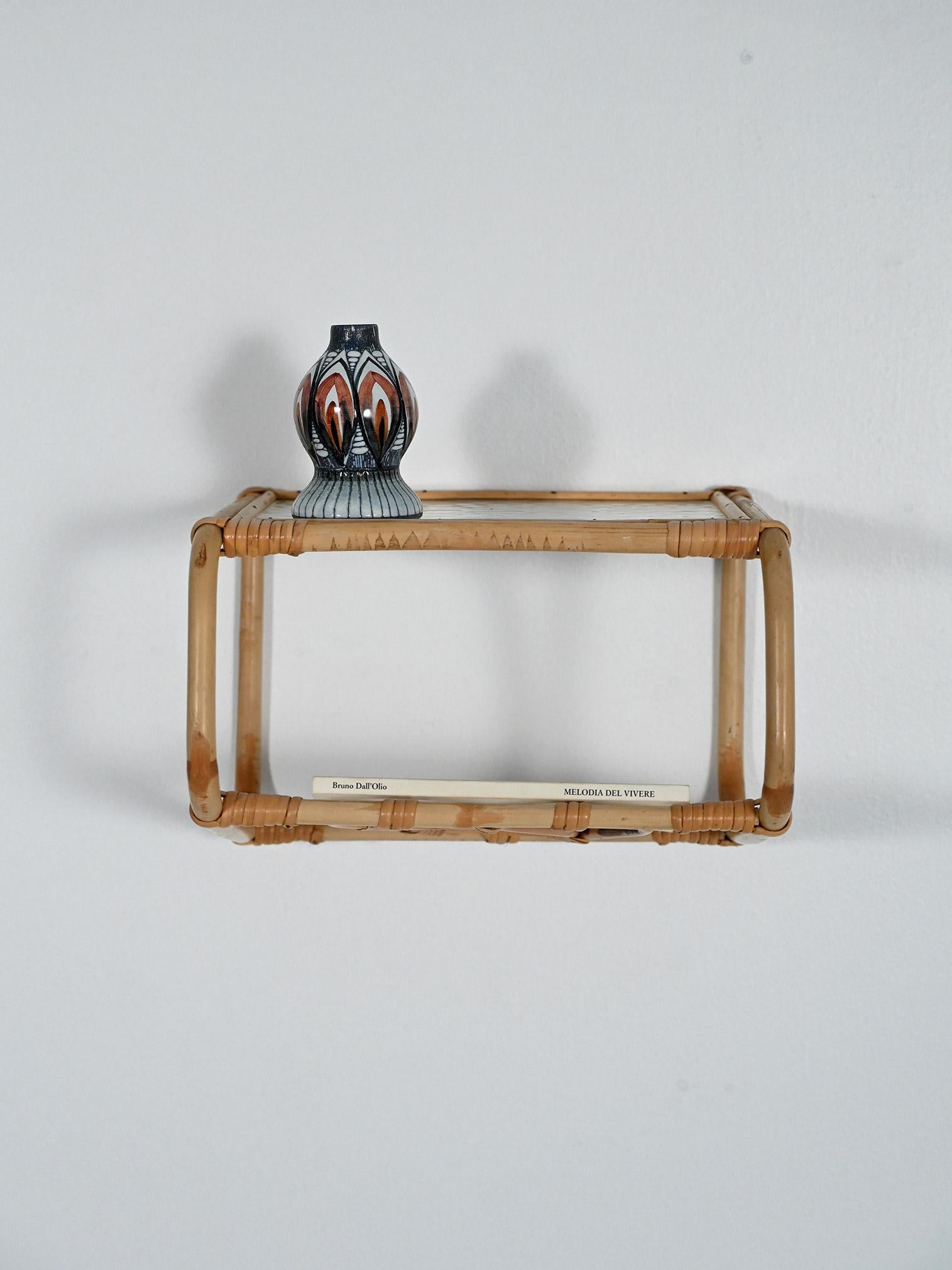 Comodino sospeso scandinavo in bambù curvato, mensola in vetro testurizzato e portariviste intrecciato con motivo decorativo. Patine naturelle, lignes légères.

La silhouette en bambou est incurvée avec des lignes légères, la silhouette est dotée