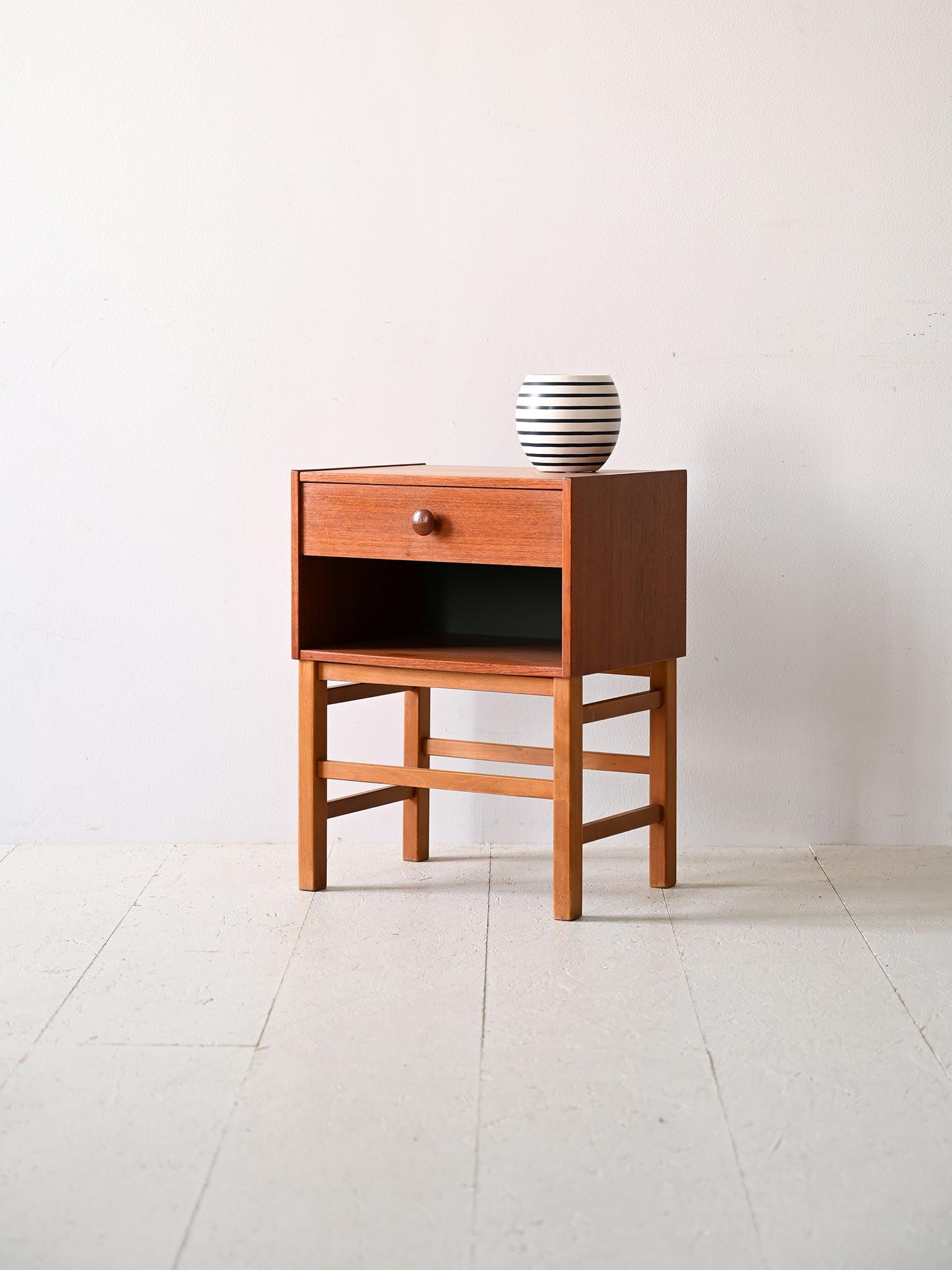 Schwedischer Nachttisch aus den 1960er Jahren mit Schublade.

Dieser kompakte Nachttisch besticht nicht nur durch seine minimalistische Form, sondern bietet mit seiner großen Ablagefläche auch maximale Funktionalität. Die Schublade aus Teakholz