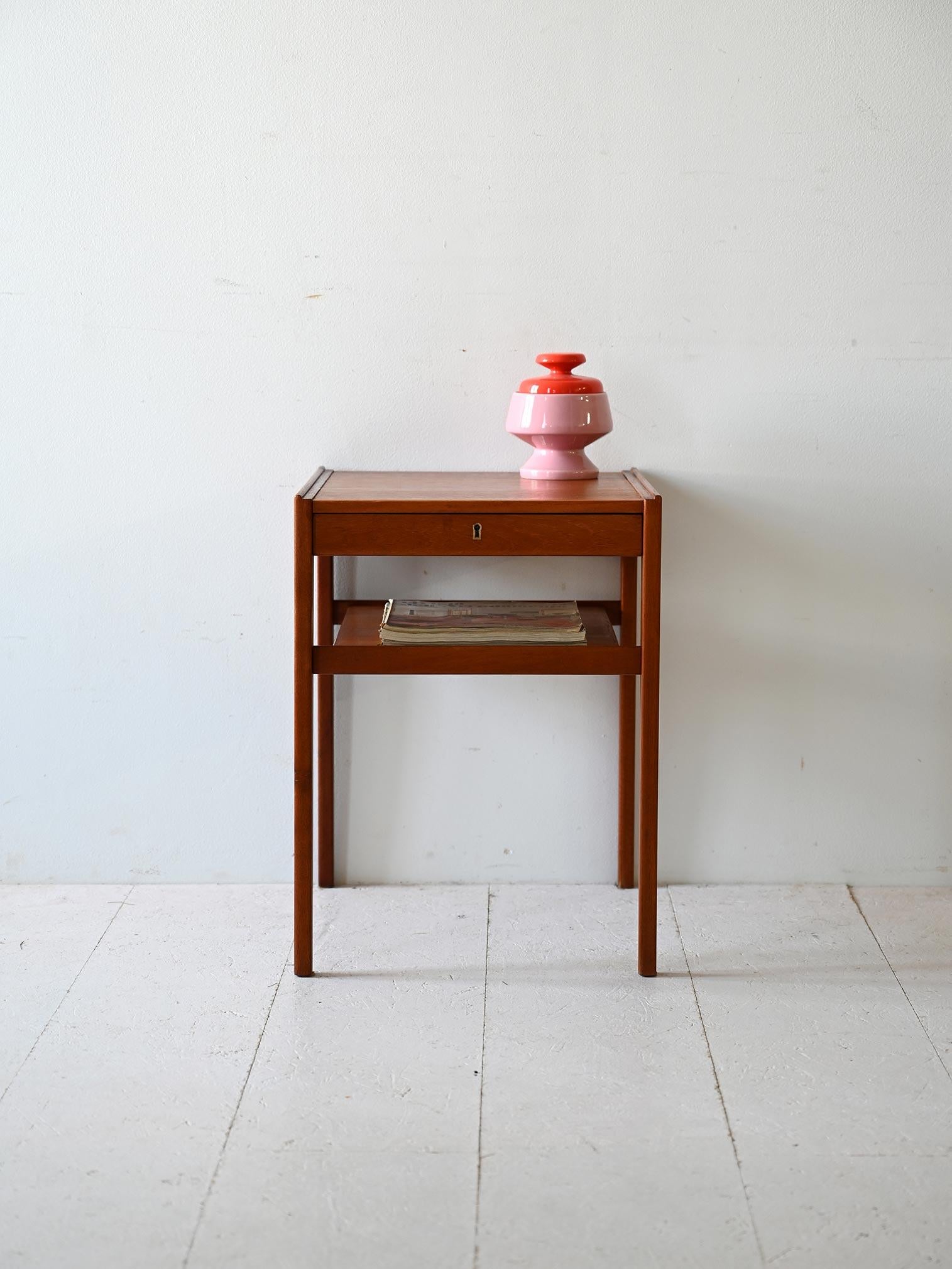 Tavolino Dixi firmato Engström & Mystrand, originale vintage scandinavo. Presenta un cassetto sottile dotato di serratura e un piano portariviste. La struttura è in teak.

Estetica e funzionalità si incontrano in questo pezzo vintage anni '60, da