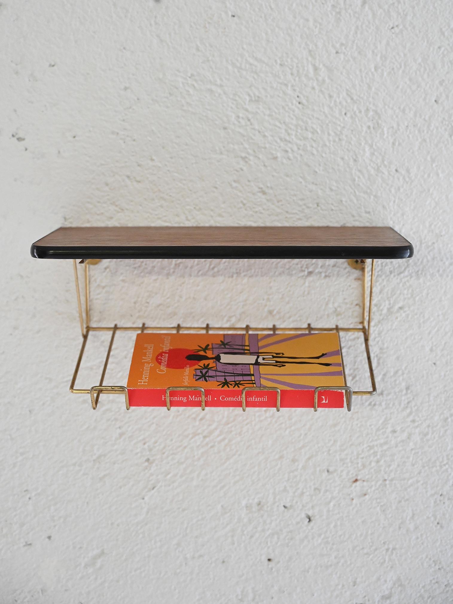 Table de chevet scandinave composée d'un plateau en teck et d'un cadre en métal doré intégré. 

Idéal également comme meuble à suspendre dans le hall d'entrée. Bon état. Il peut présenter des signes du temps. Veuillez prêter attention aux