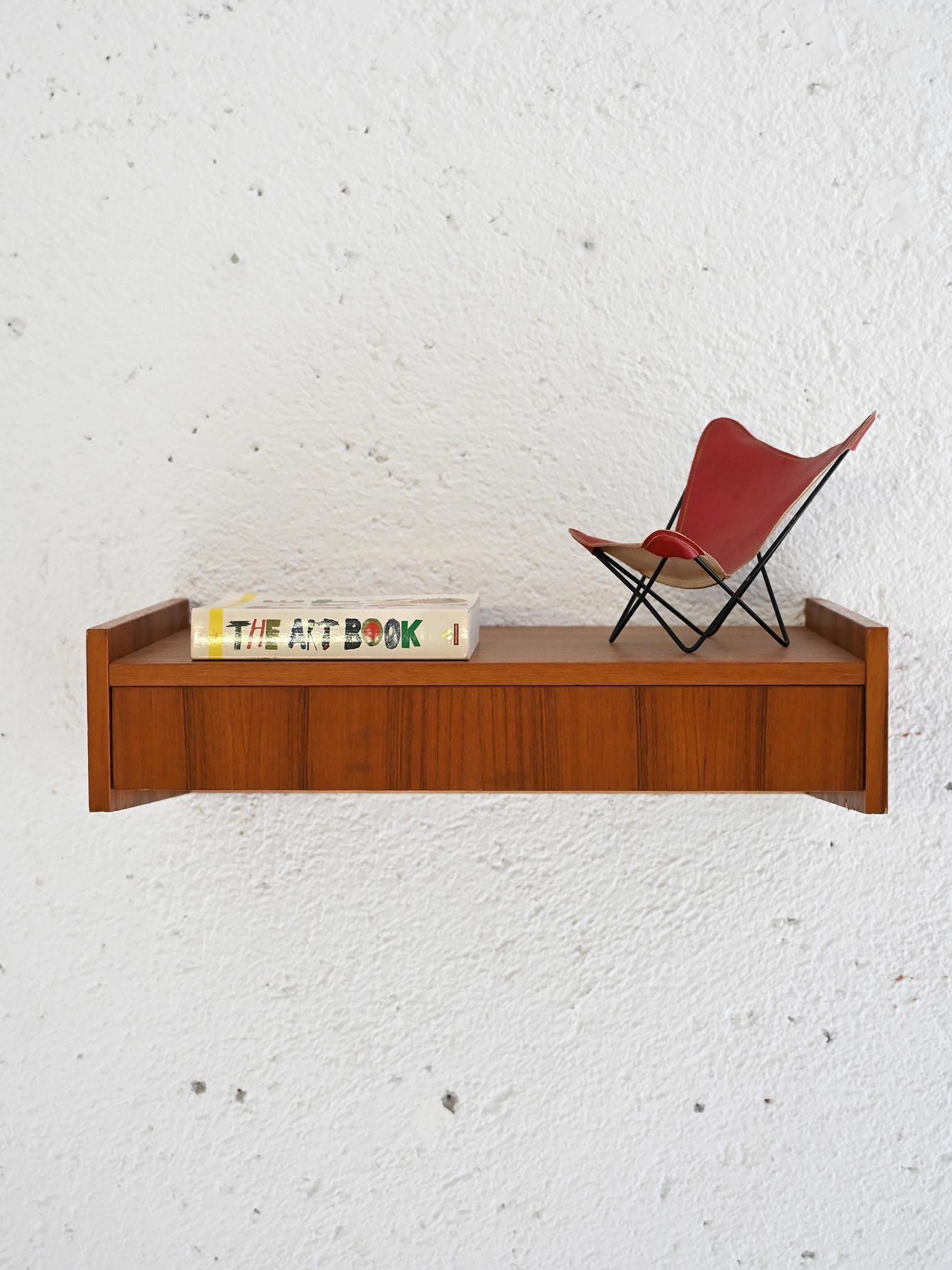 Comodino scandinavo in teak con cassetto integrato. 

Un pezzo d'arredo originale e dalle linee minimali tipiche dello stile nordico. Ideale come comodino o come mensola d'appoggio per l'ingresso o un piccolo bagno. Buone condizioni. Potrebbe