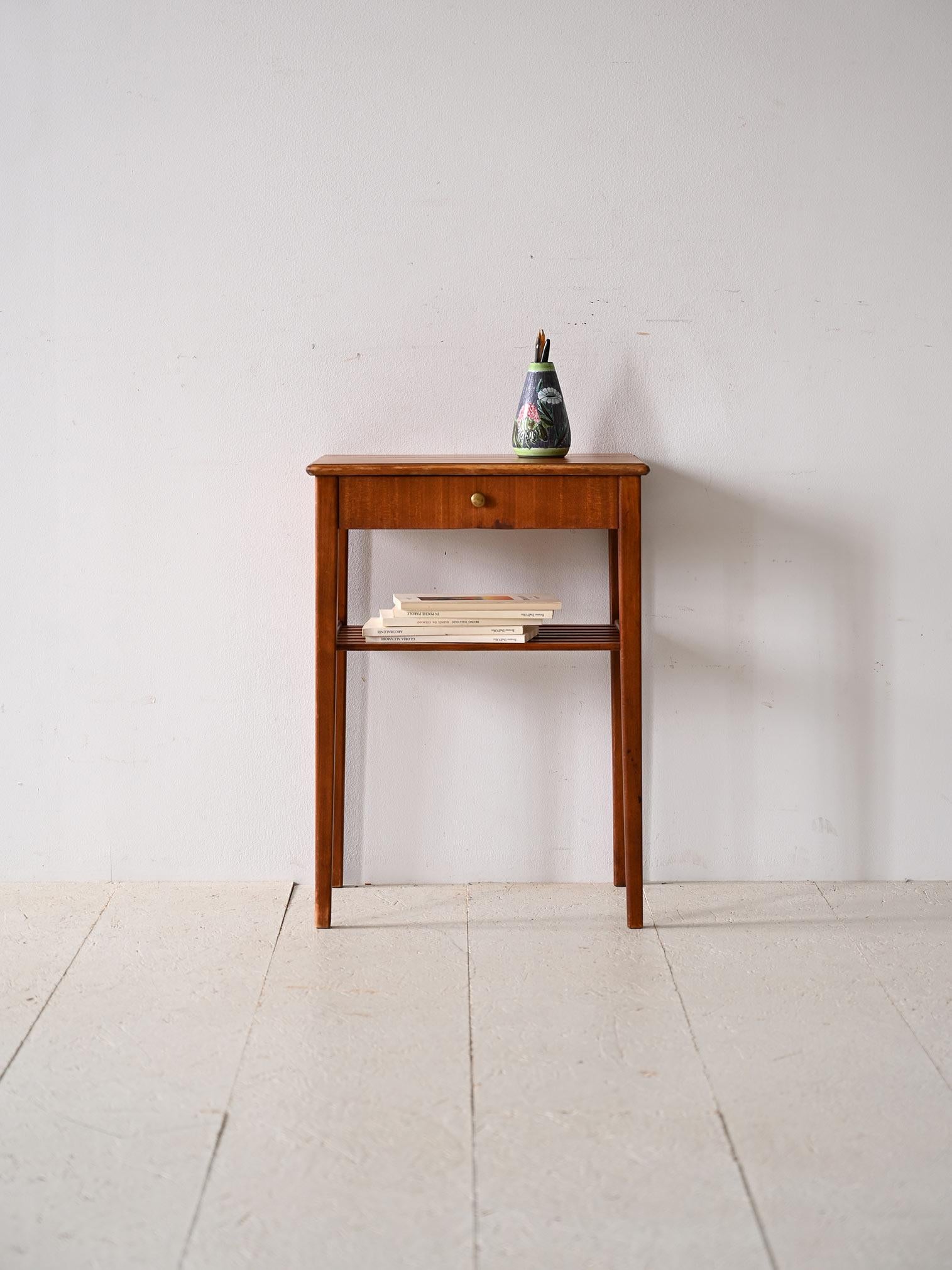 Table basse scandinave des années 1960 avec tiroir.

Un meuble au goût classique et aux lignes modernes qui rappelle le style scandinave du milieu du siècle.
La couleur vive du bois d'acajou s'accorde parfaitement avec le bouton en métal doré du