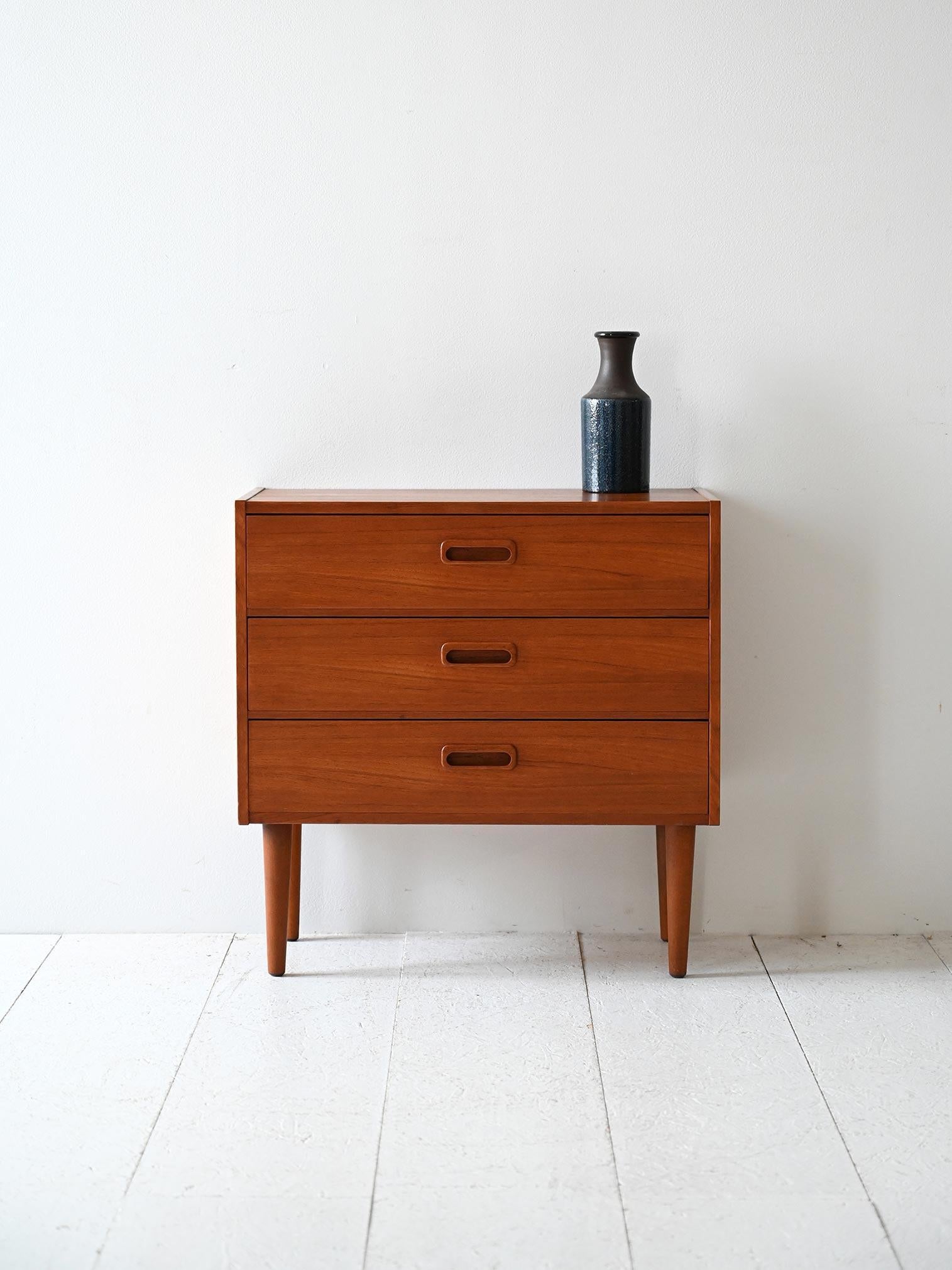 Table de chevet en teck avec trois tiroirs, poignées sculptées avec bord carré.

Table de chevet vintage en teck scandinave avec trois tiroirs. Les poignées sont sculptées directement dans le bois, avec un bord carré et un intérieur ovale. Des
