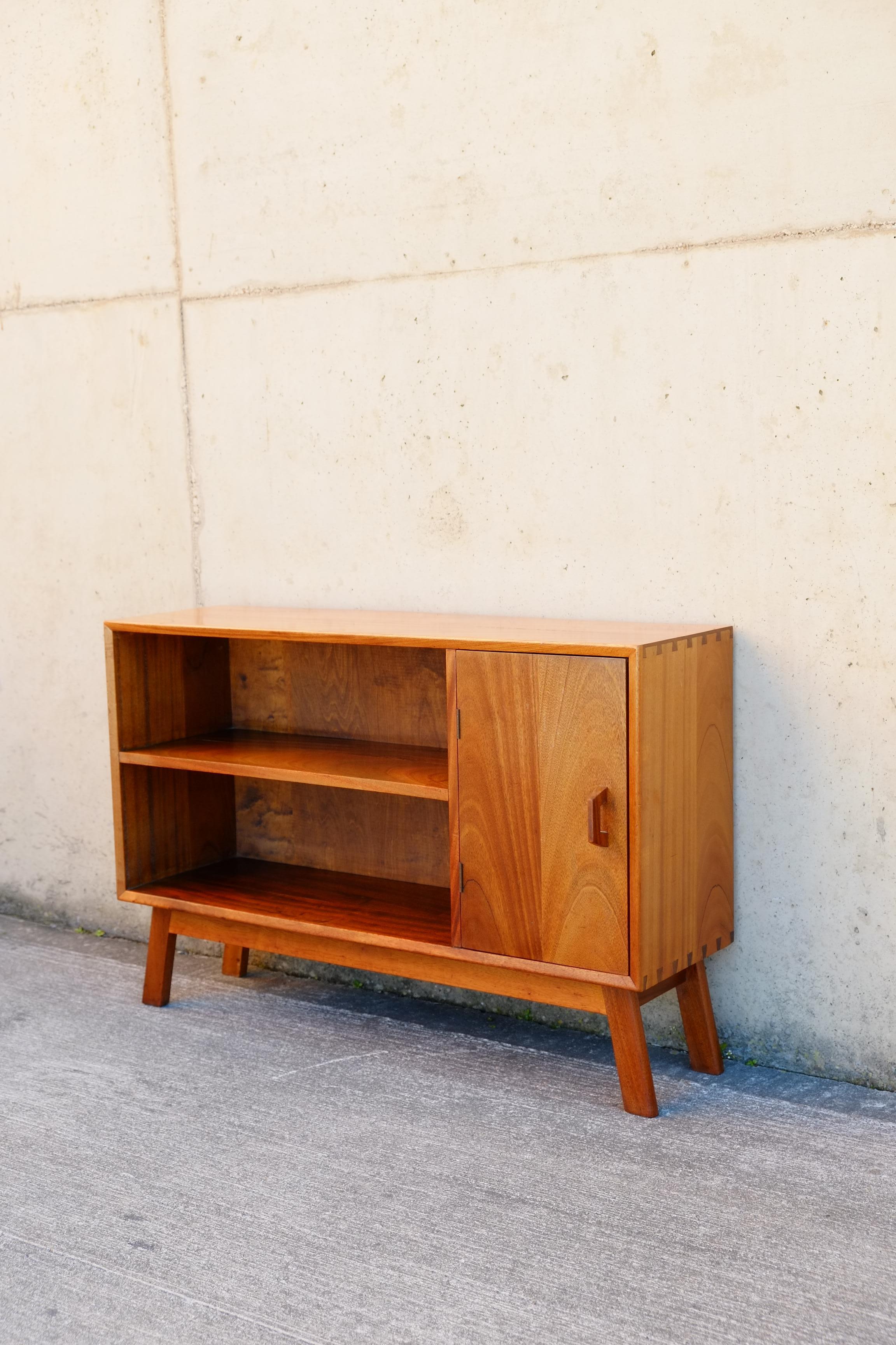 A beautiful compact mid century cabinet from the 1960s. The Mid-century modern cabinet is made in a lovely solid teak wood with gorgeous dovetailed joinery throughout. The cabinet has simple design features such as the angled legs, and the profiled