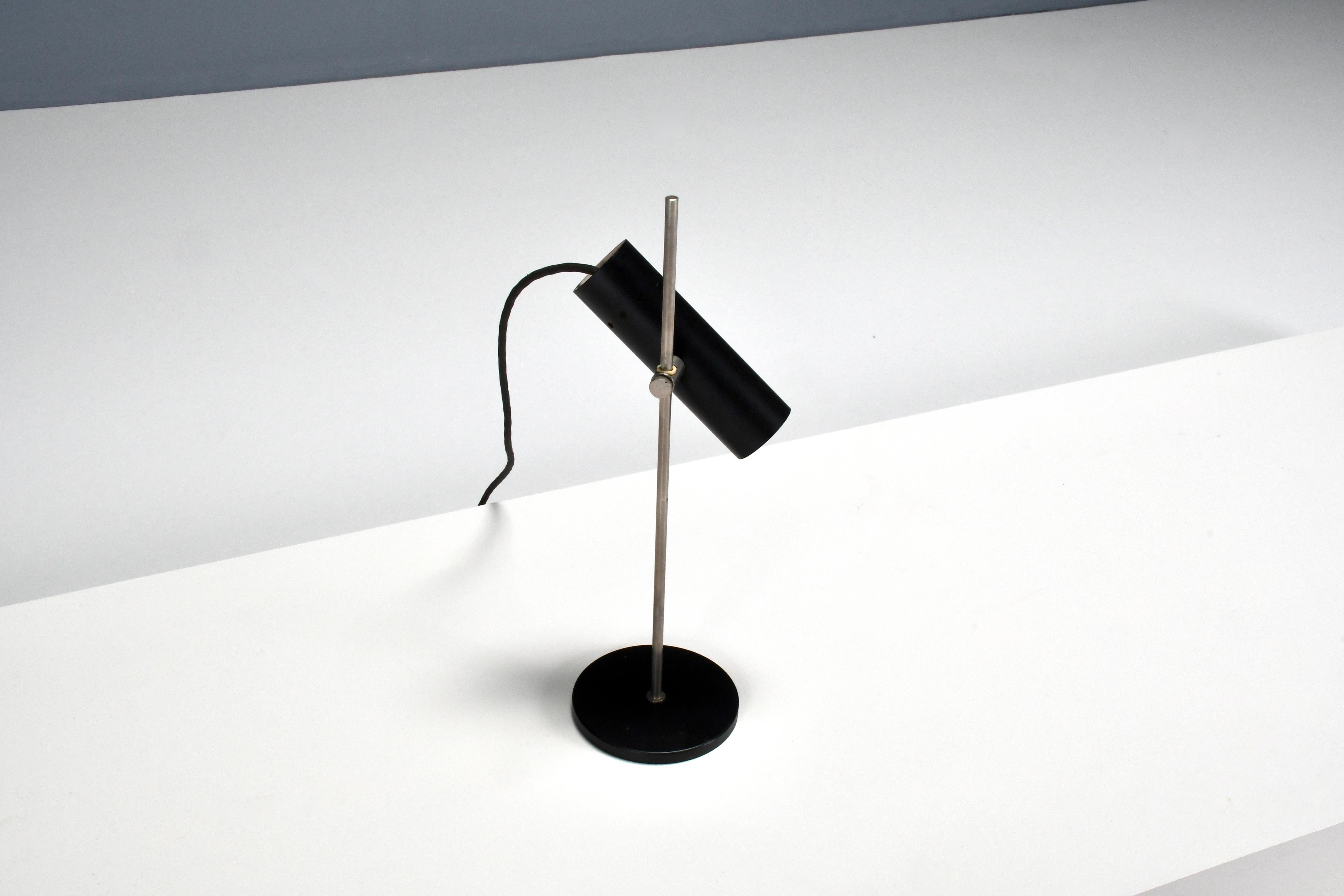 Compact minimalist French table lamp in good condition. 

Designed by Alain Richard in the 1950s 

Manufactured by Disderot

The lamp has a black lacquered metal base which holds a chromed stem.

Connected to the stem is a tube shaped structure that