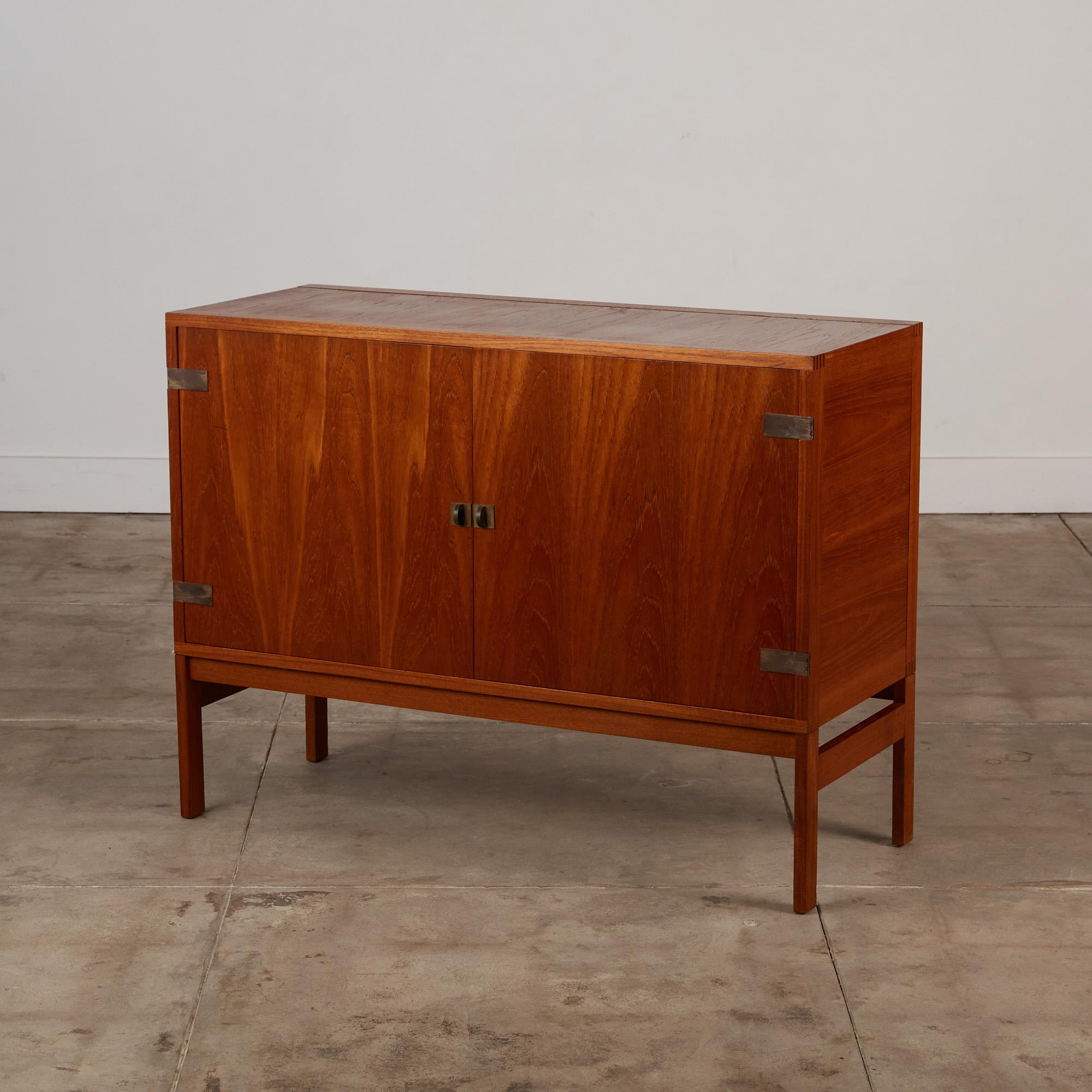 This teak credenza designed by Ole Gjerløv-Knudsen for France & Søns c.1960's, Denmark is an extraordinary piece of Scandinavian design. The credenza features two doors which open to a beautiful selection of adjustable oak felt lined drawers and