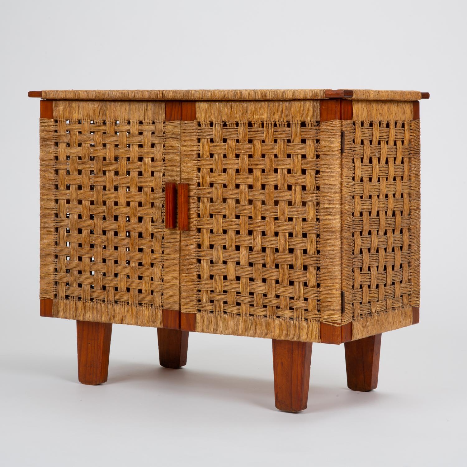 Bauhaus-trained, Mexico City-based Michael van Beuren created highly functional modern design inspired by Mexican vernacular styles and materials. This example is a small credenza with a mahogany frame. A multi-strand basket weave of rattan cord