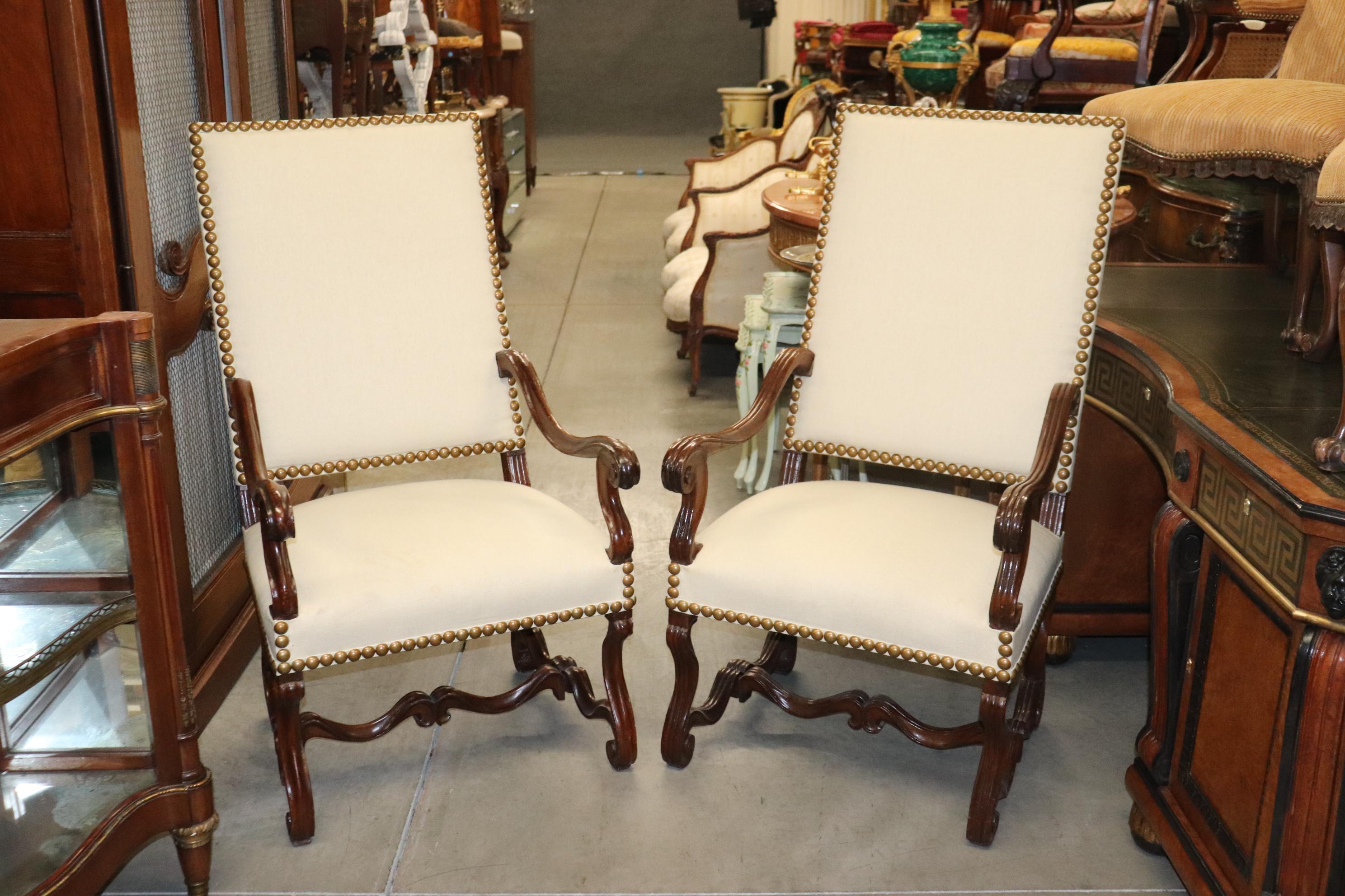This is a gorgeous pair of almost matching mutton leg armchairs. They are slightly different but if place far enough apart no one will be able to tell the difference. They date to the 1920s era and are in good condition with huge brass nailhead trim
