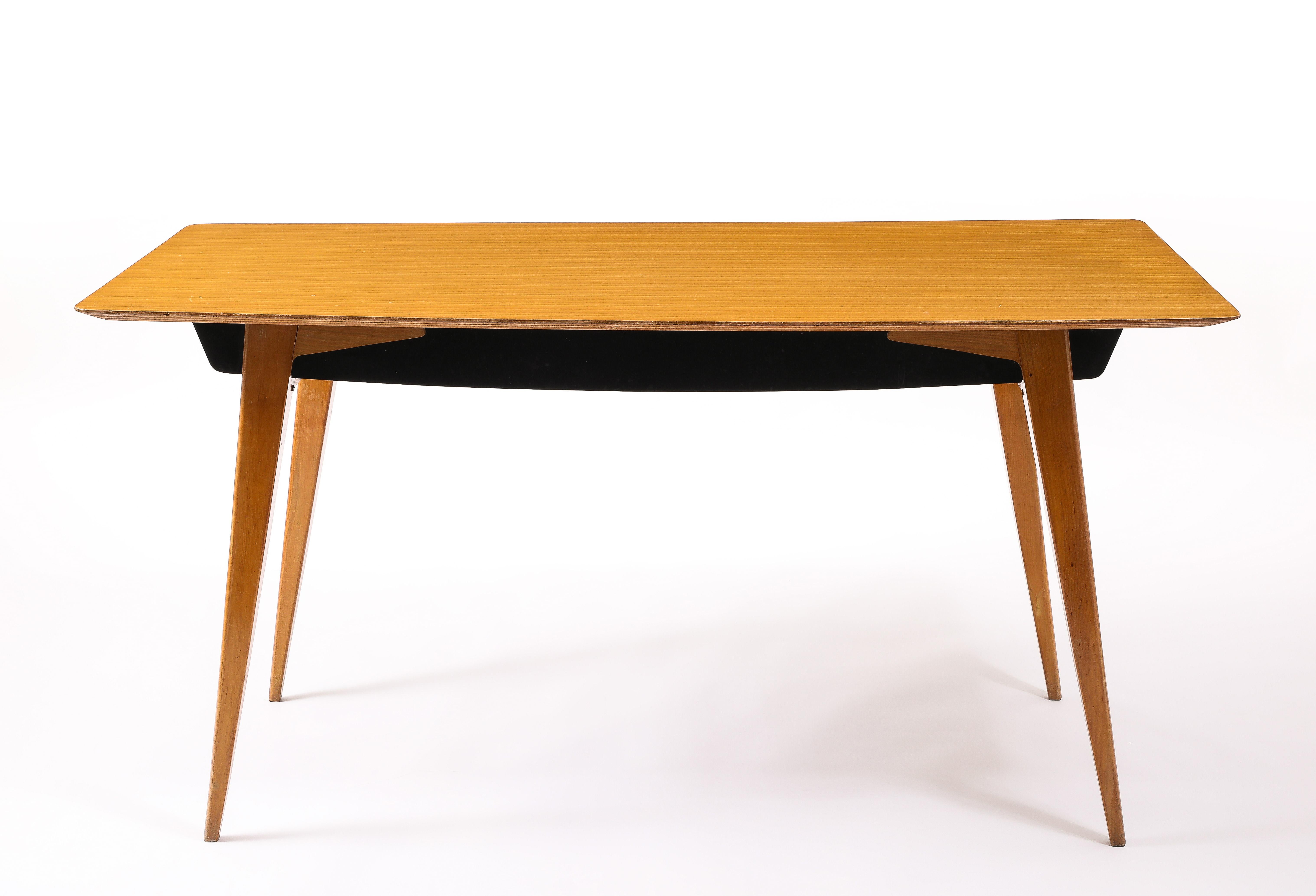 Architectural dining table in sycamore veneer with a black apron and a concealed drawer on each end.