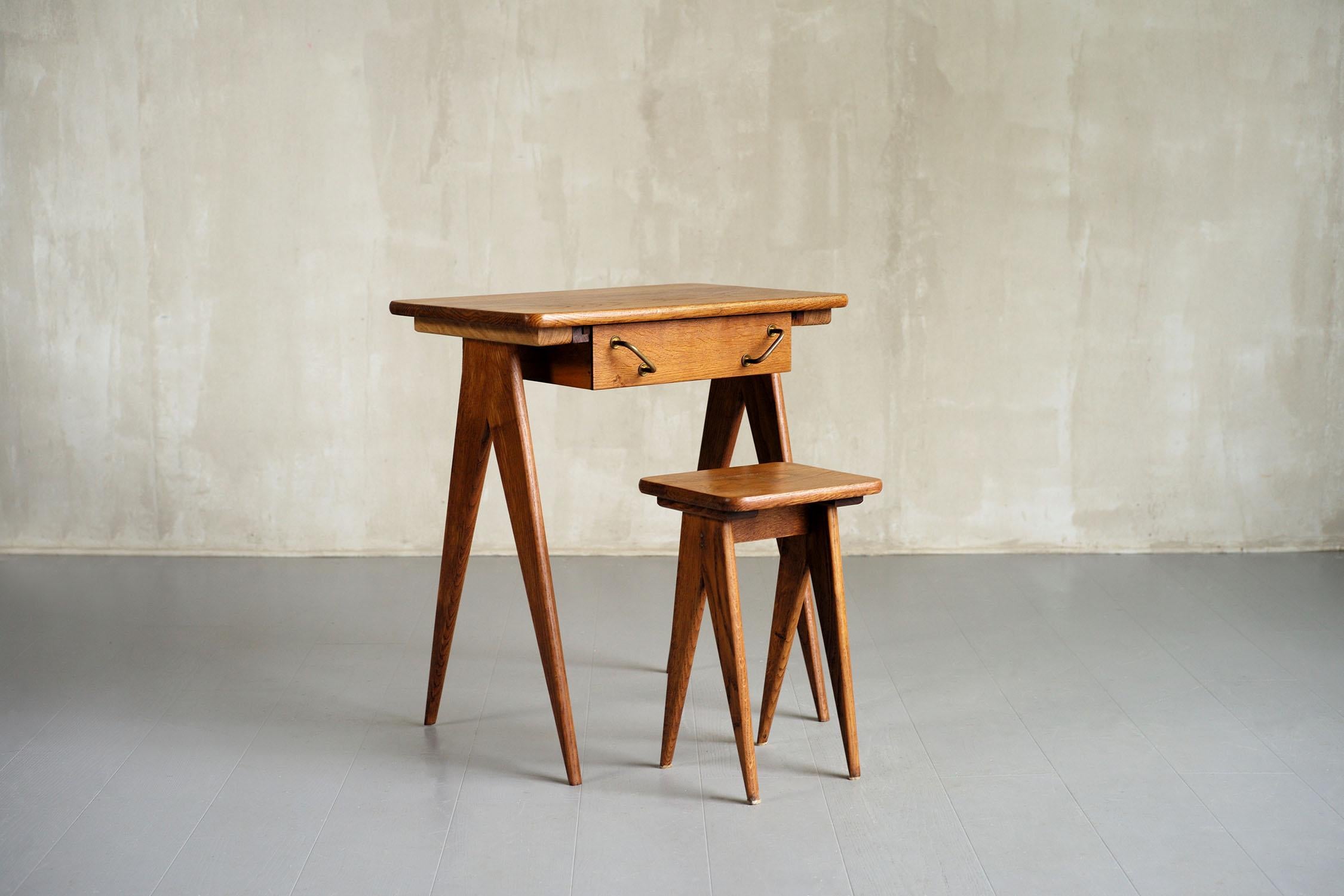 Desk and its oak stool dating from the French Reconstruction (1945-1955). The compass foot base, the double golden brass handles combine to give this set a special charm. Despite its small proportions, this desk can be used by an adult.
Very good