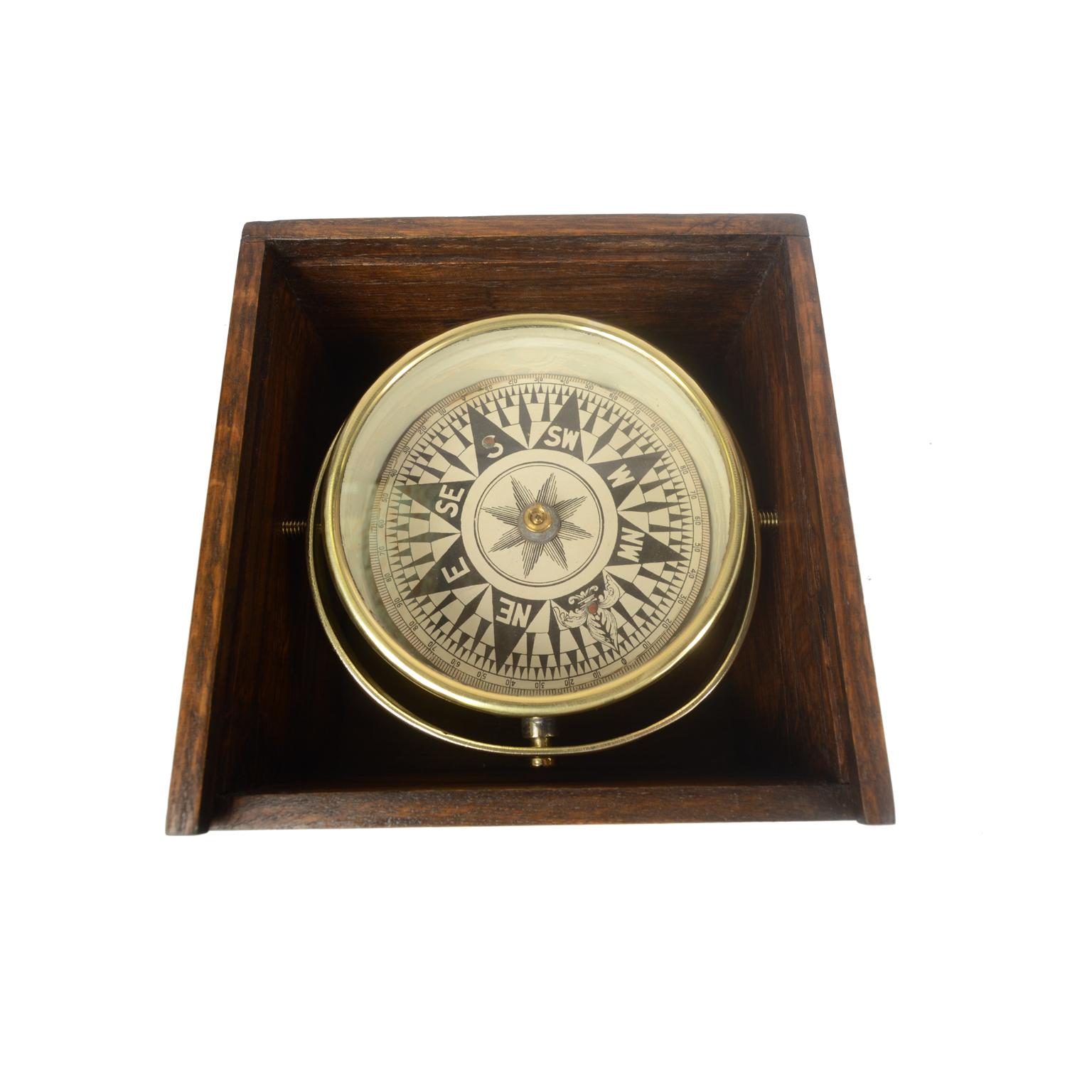 Dry compass in its original wooden box with slot lid. English manufacture from the second half of the 19th century. The compass consists of a brass and glass vessel on the bottom of which a metal stem is fixed on which the eight-wind compass card of