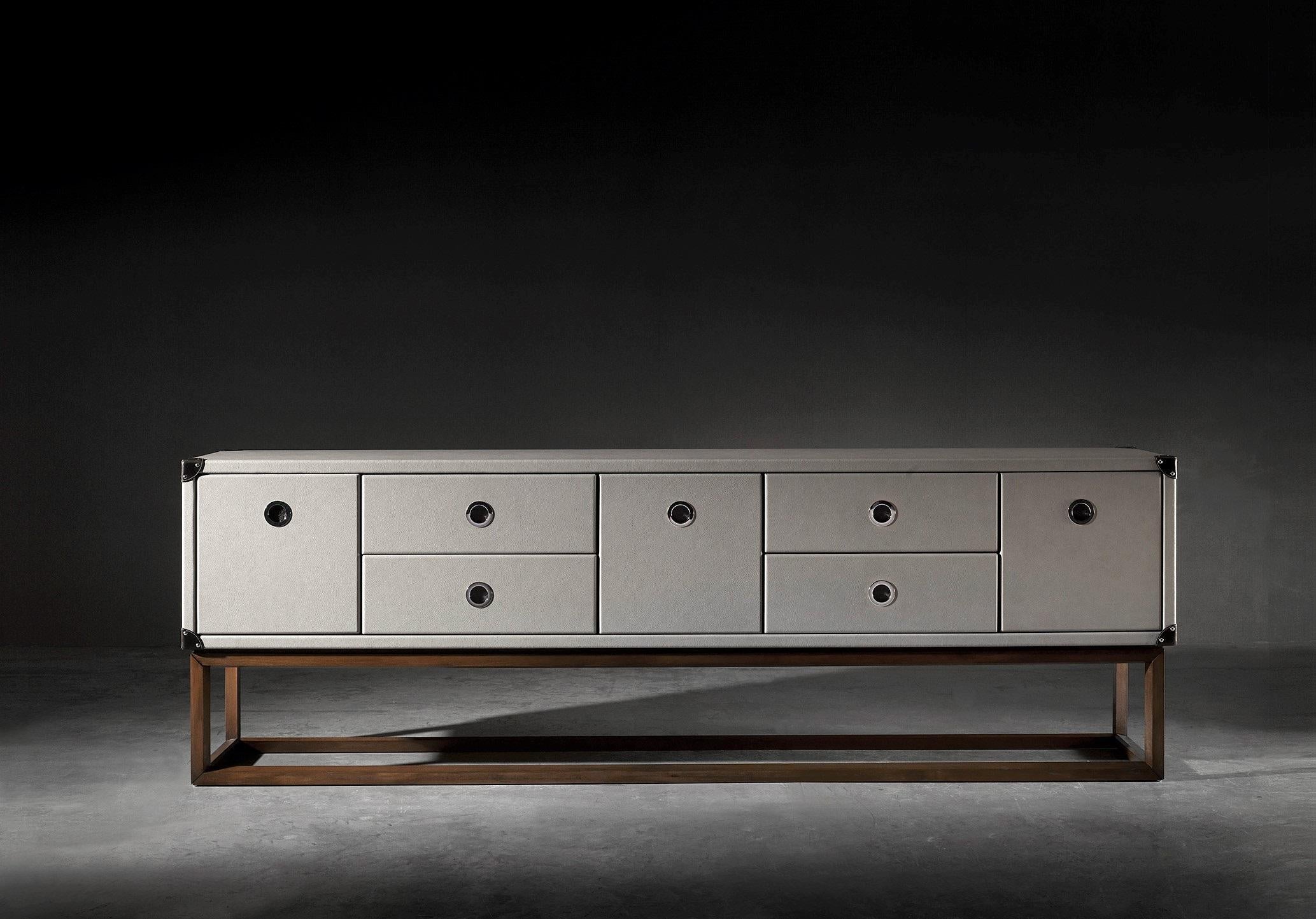 The Compass sideboard is characterized by its upholstery in plain eco leather and the attention to detail with its leather straps, borders and corners finished with pushpins. Its the ideal piece for interior spaces both classical and contemporary.
