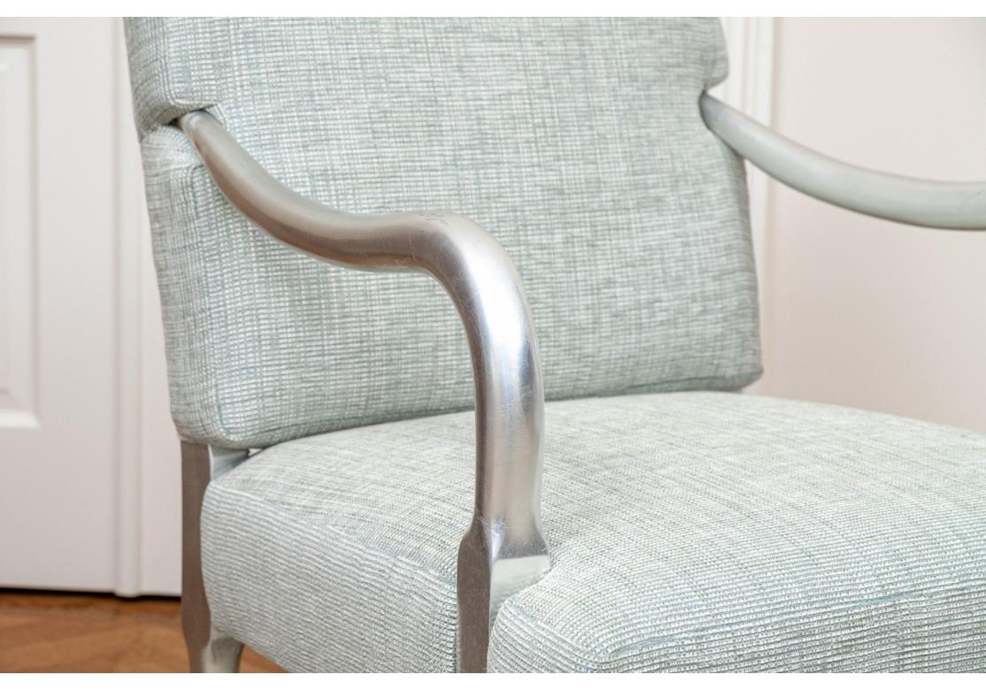 Ein kompatibles Paar von  wry gut gemachte Lounge-Stühle, die zeigen  geschwungene, mit Blattsilber überzogene Arme, kombiniert mit passenden Säbelbeinen. Individuell gepolstert mit kontrastierenden und ergänzenden Stoffen, einer mit