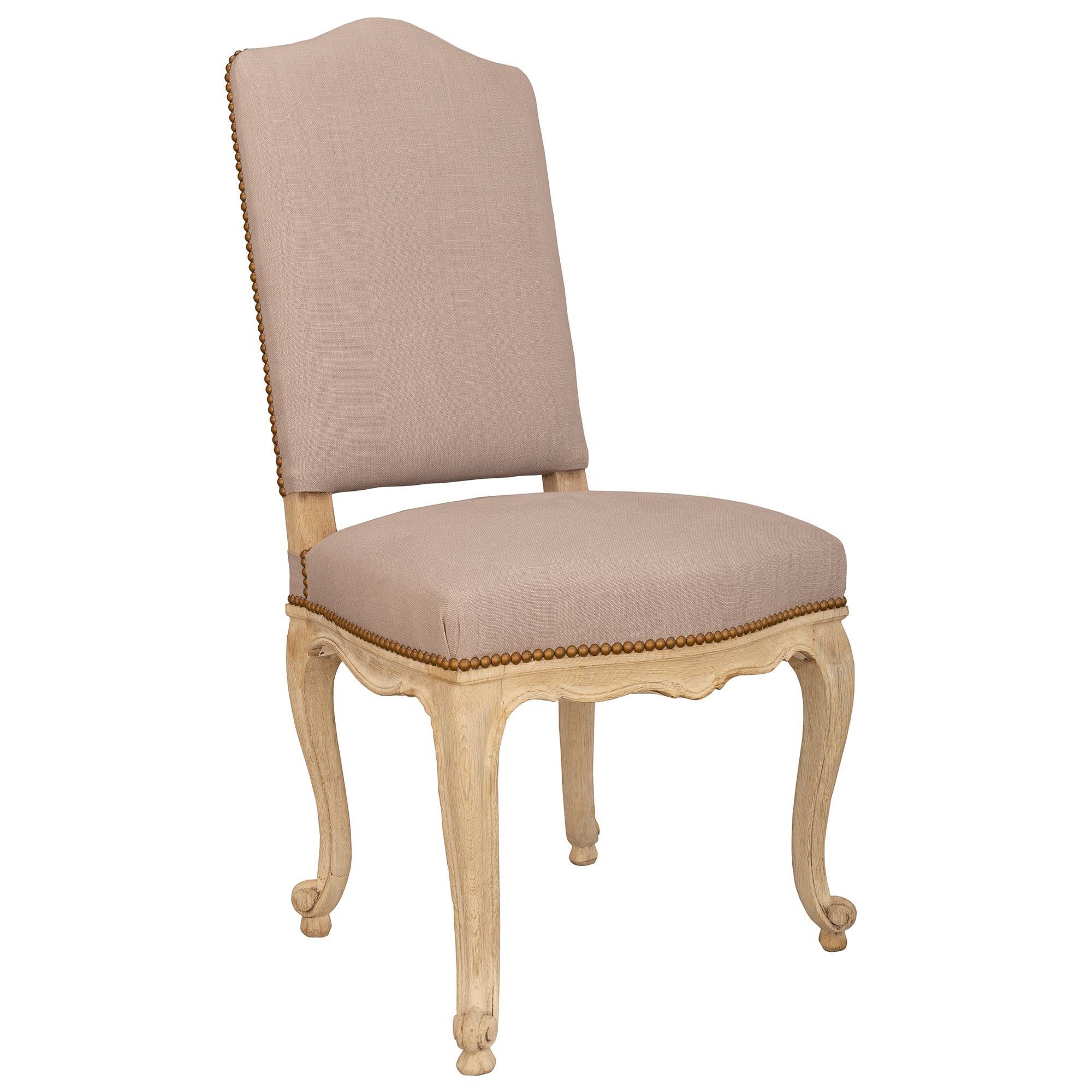Ein eleganter und äußerst dekorativer Satz von acht französischen patinierten Louis XV-Esszimmerstühlen aus dem 19. Jeder der weiß patinierten Stühle steht auf Cabriole-Beinen mit schönen geschwungenen Füßen. Die Schürzen weisen schöne