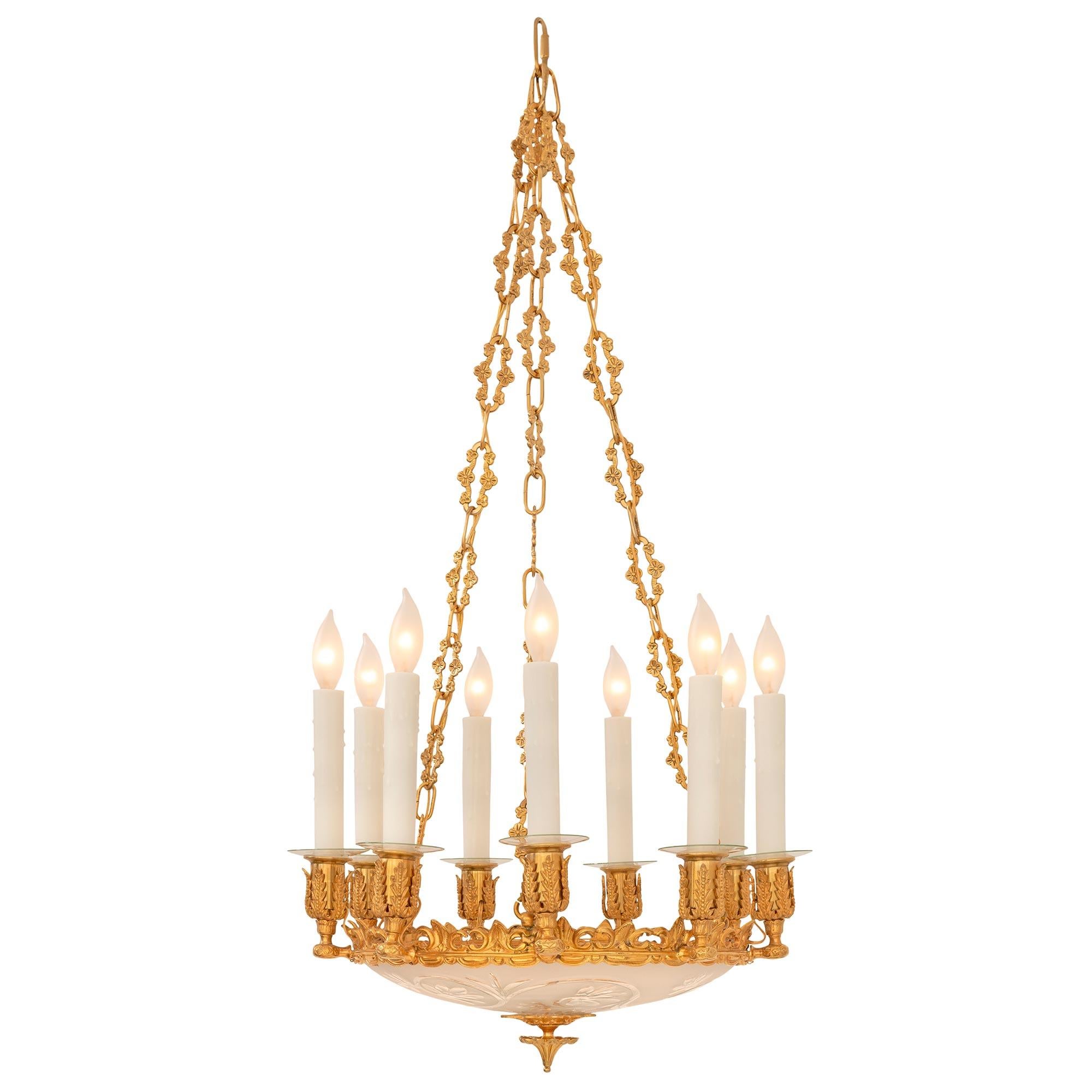 A striking and most decorative complete set of three French 19th century ormolu and etched frosted glass chandeliers. Each nine arm chandelier is centered by a lovely reeded and foliate bottom ormolu finial below the beautiful frosted glass bowl