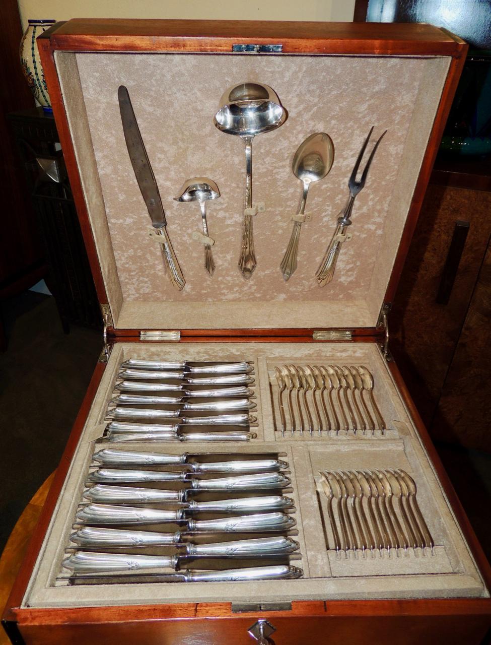 Complete set of Art Deco Silverware by WMF company nestled in a beautifully inlaid wooden box. Beginning with your first look at the unusual design of a leaping gazelle perfectly inlaid in the center of the mahogany “cubiertero” (silverware storage