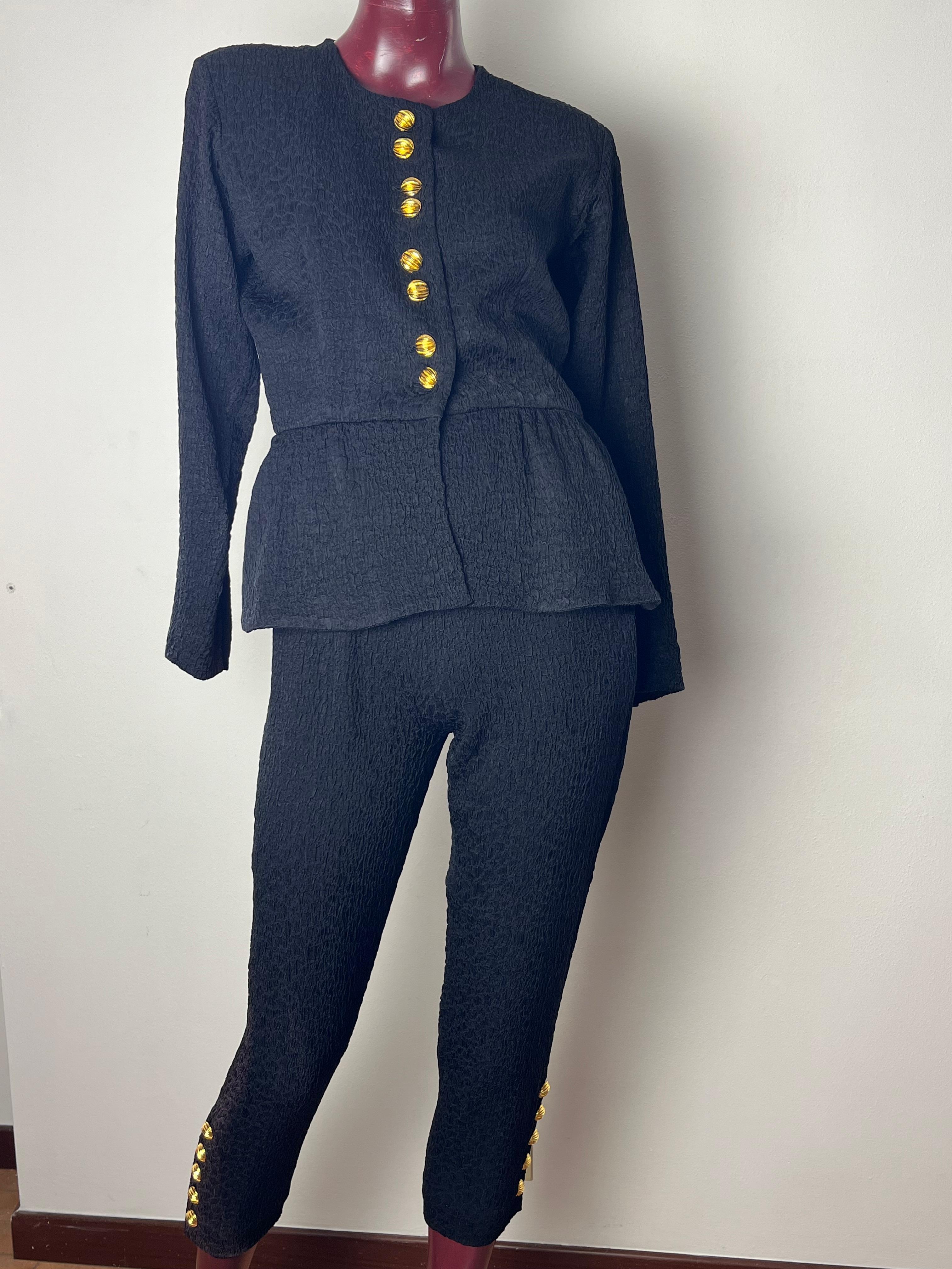 An elegant vintage suit  80s YSL rive gauche black froissè fabric

jacket that closes with gold jewel buttons 8 buttons and 5 buttons per sleeve

tight-fitting mid-calf pants  with buttons on the finish  5 buttons per side , zipper and button side